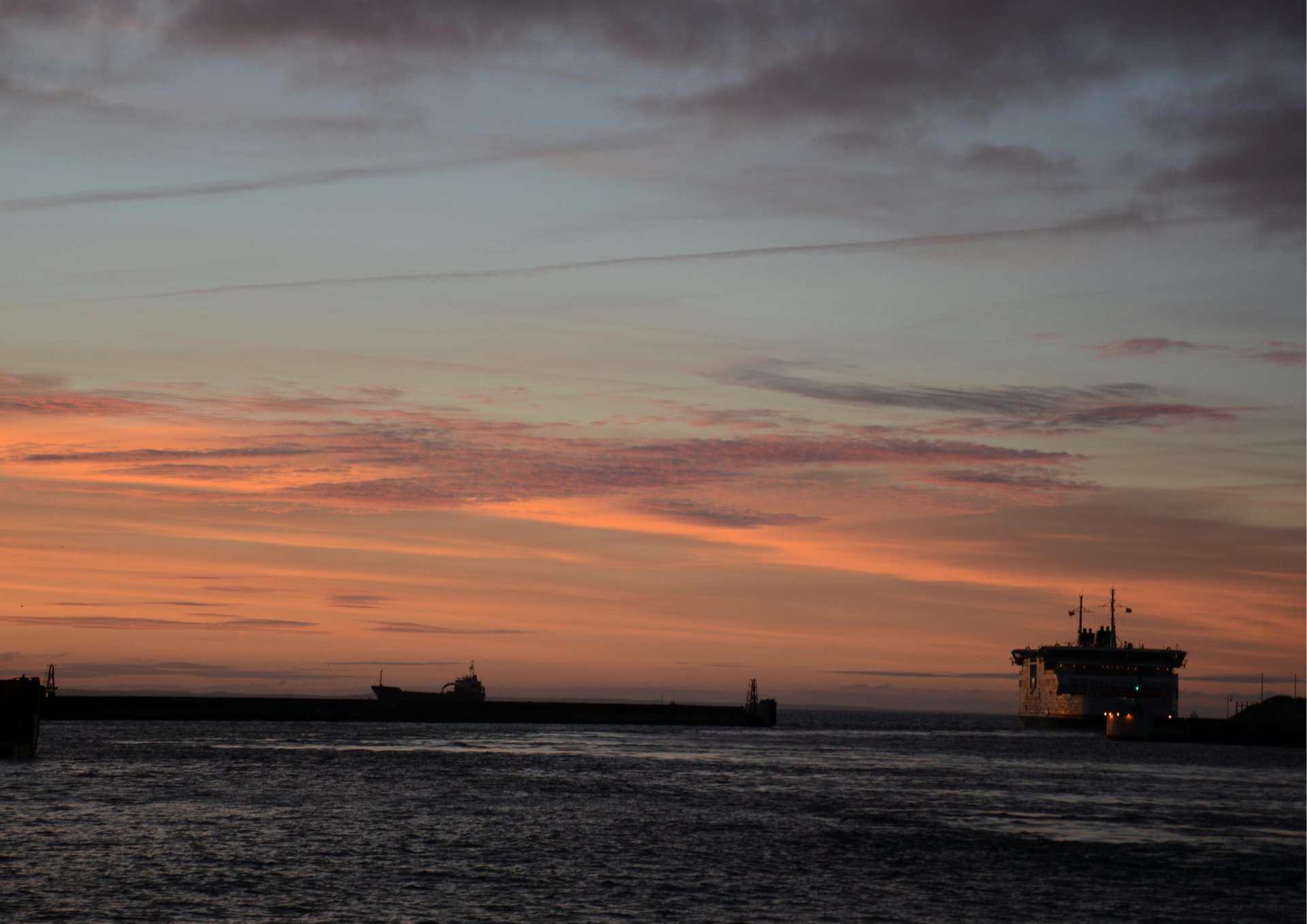 red and white cargo ship on sea during sunset