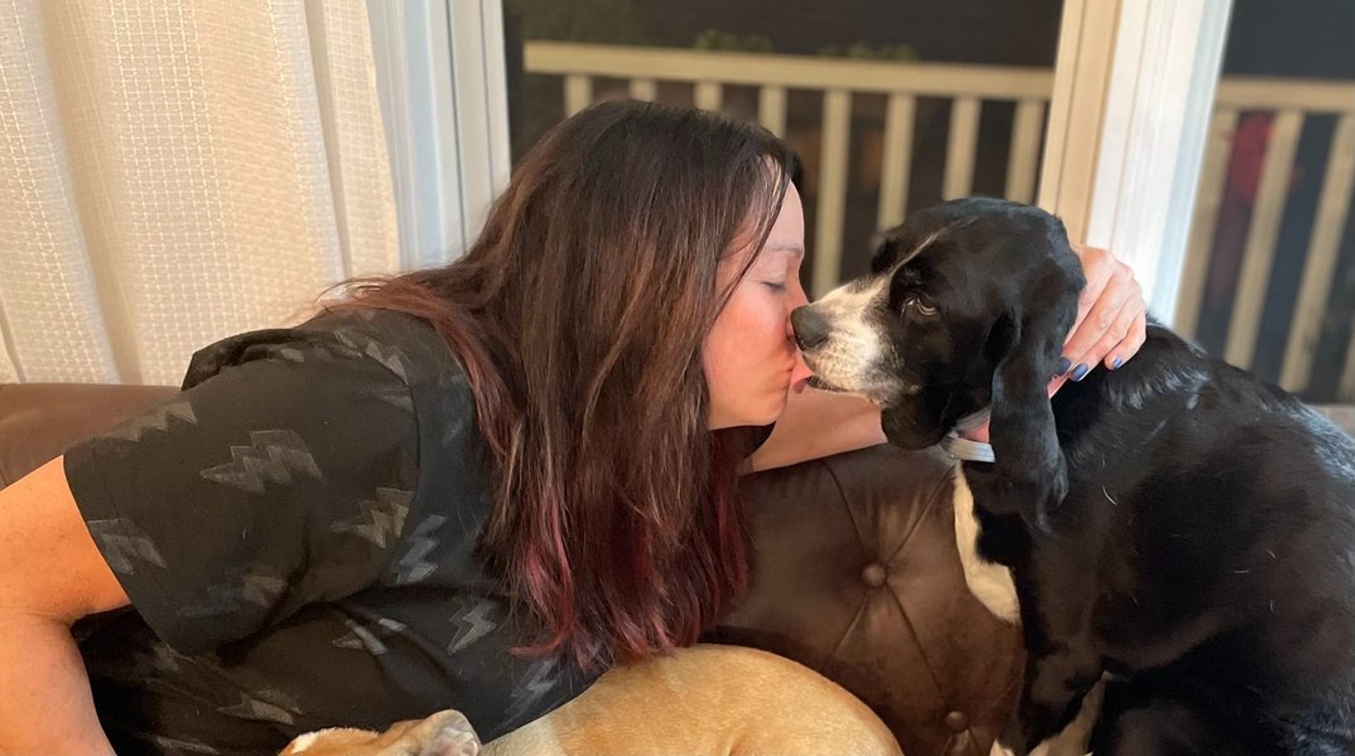 woman in black pants standing on window during daytime