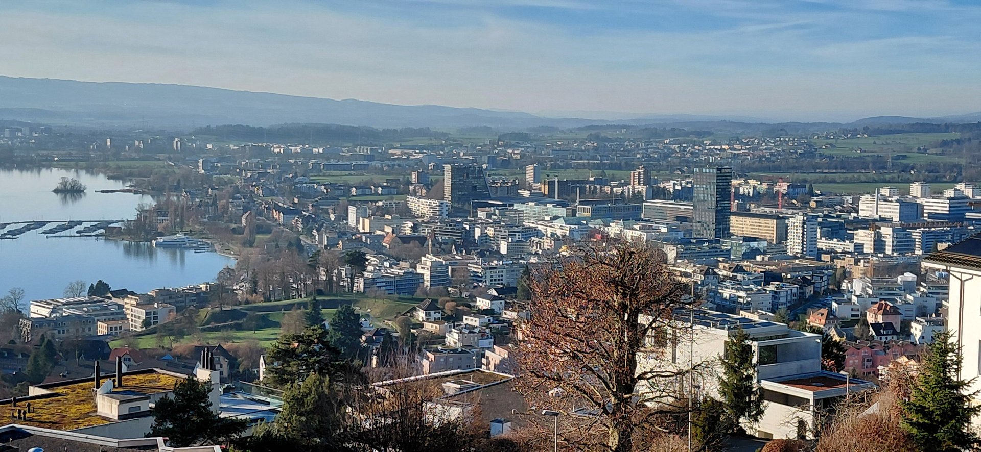 A clock tower with blue and white striped flags.