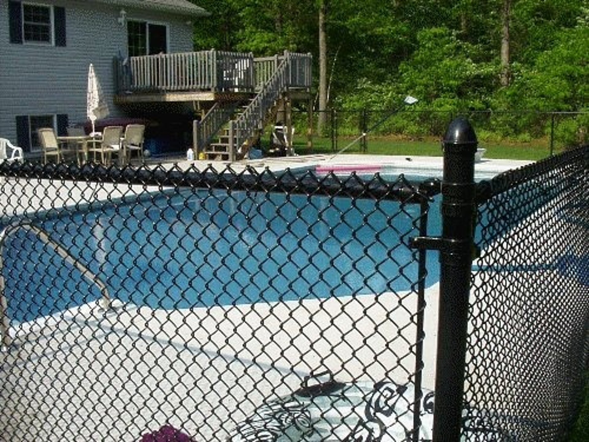 A backyard with a deck and a fence