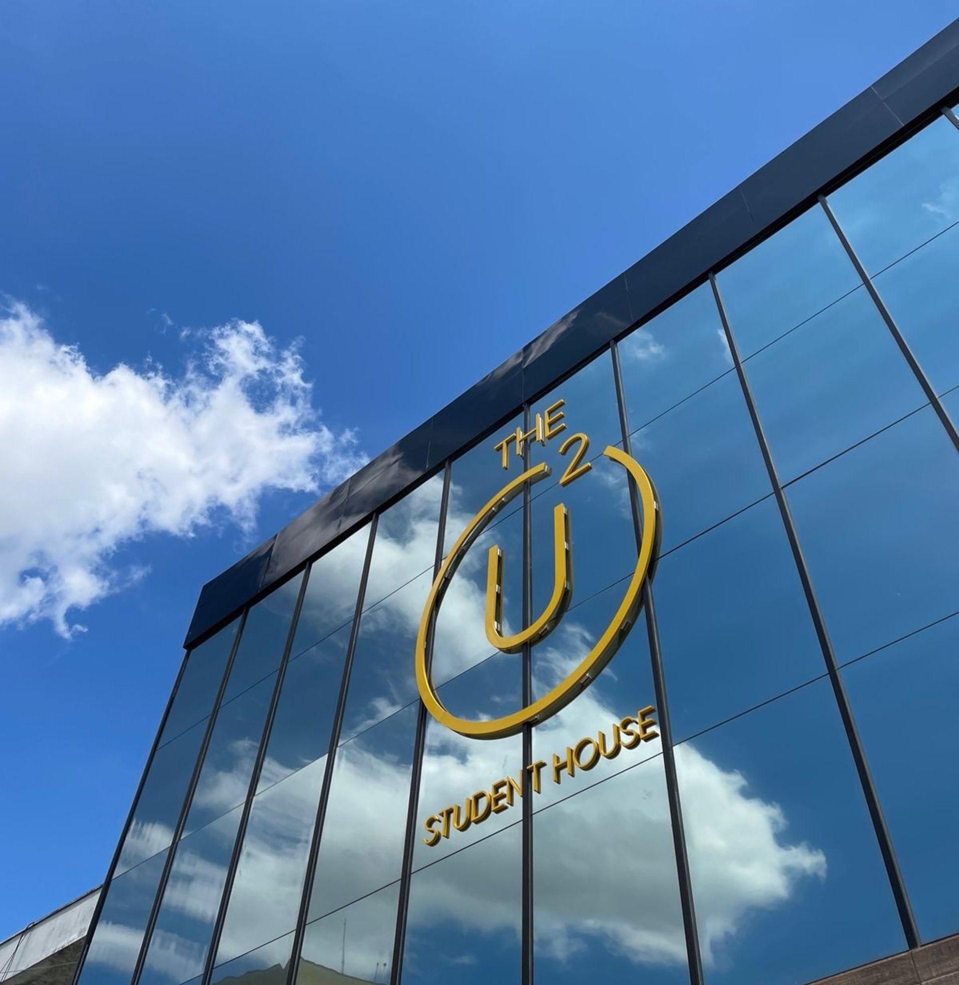 an abstract photo of a curved building with a blue sky in the background
