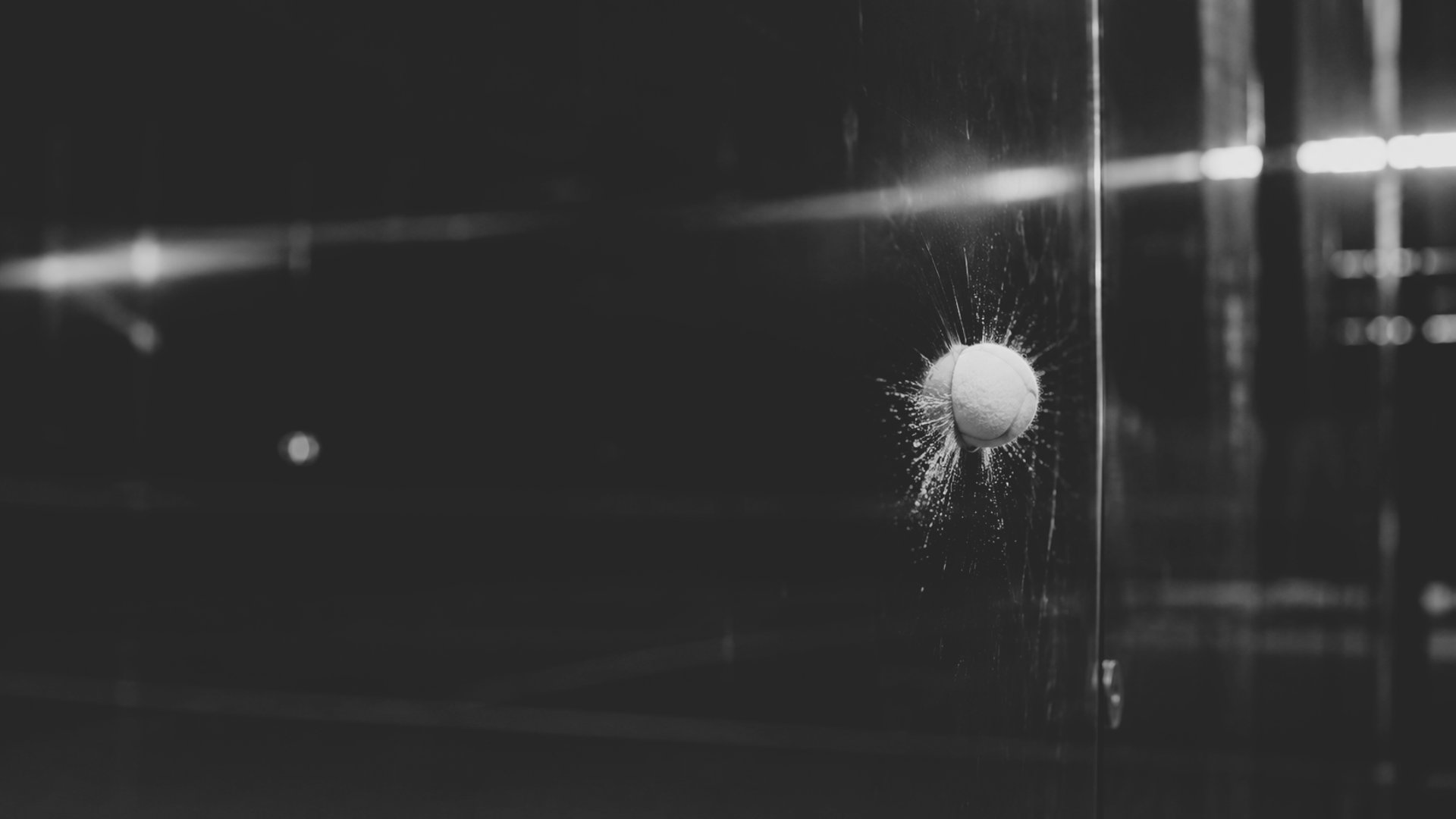 Padel ball hitting glass court wall