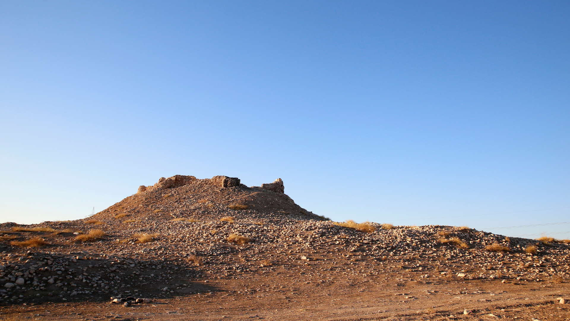 green grass field and mountains under blue sky during daytime