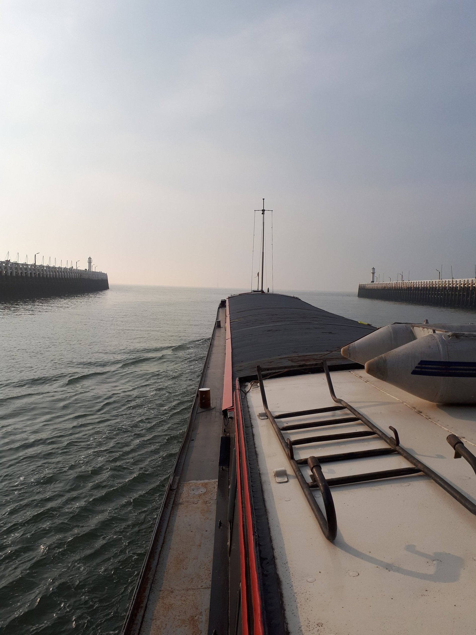 Une péniche dans un canal maritime vers la mer