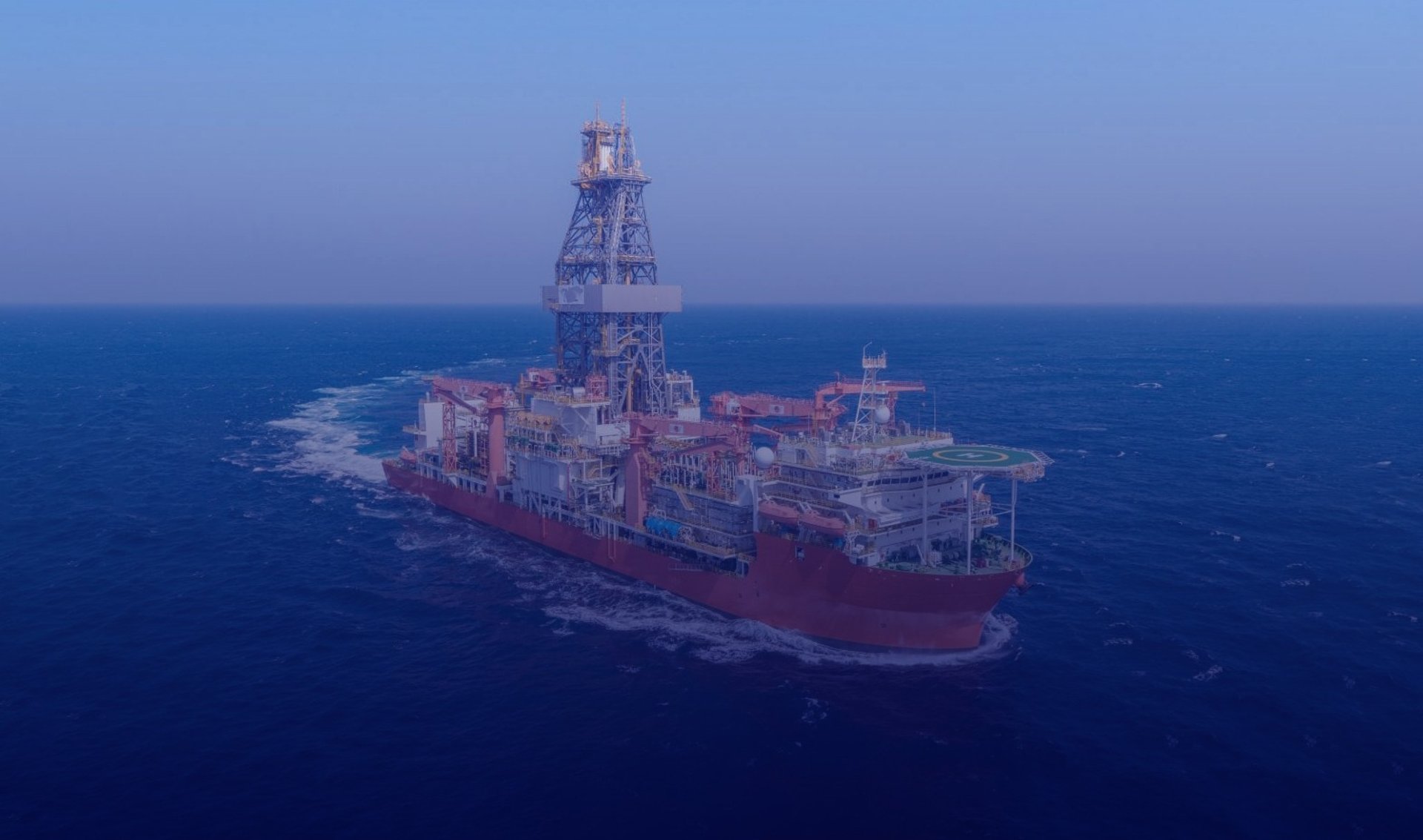 An oil rig being serviced by a supply ship.