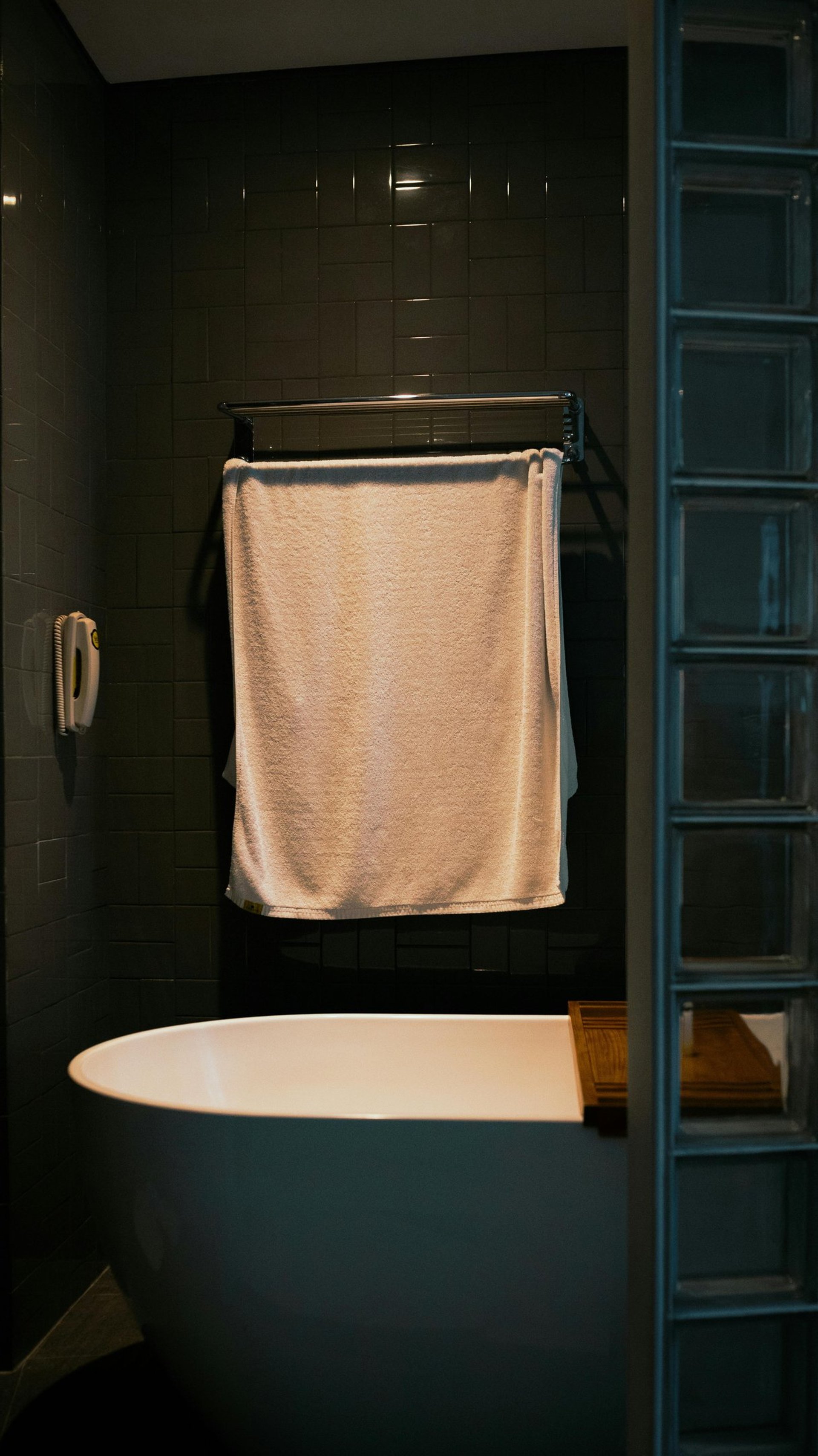 A towel hangs over a bathtub edge.