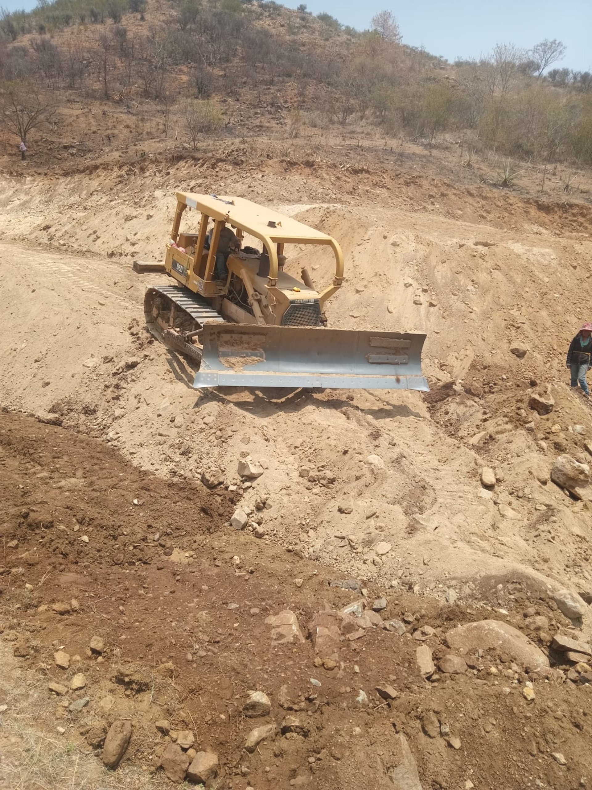 orange and white excavator on brown ground during daytime