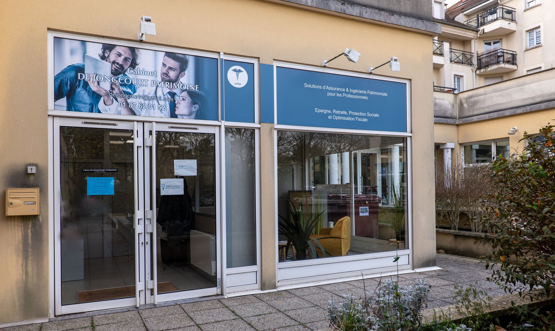 three plants in pots near brown wooden door