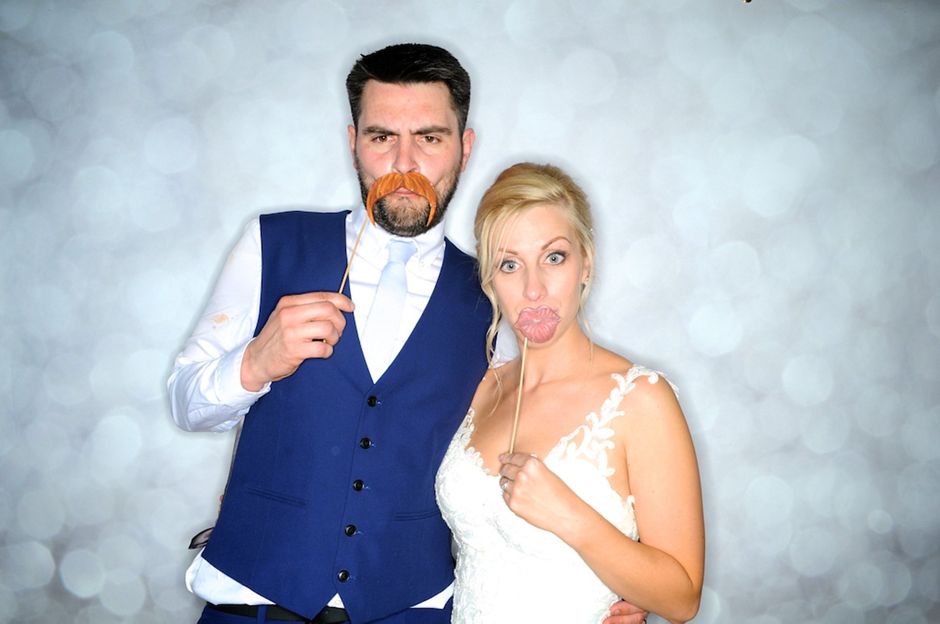 couple en tenue de mariage dans un photobooth