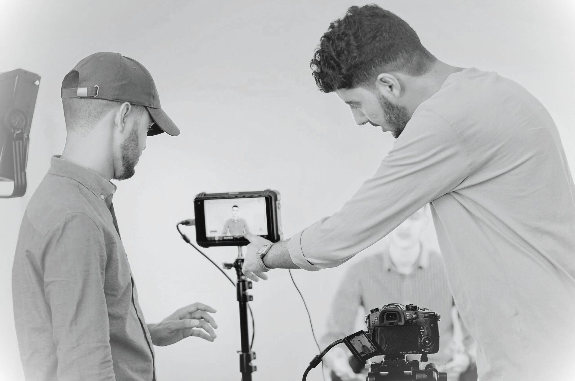 woman in black long sleeve shirt and blue denim jeans sitting on white concrete wall