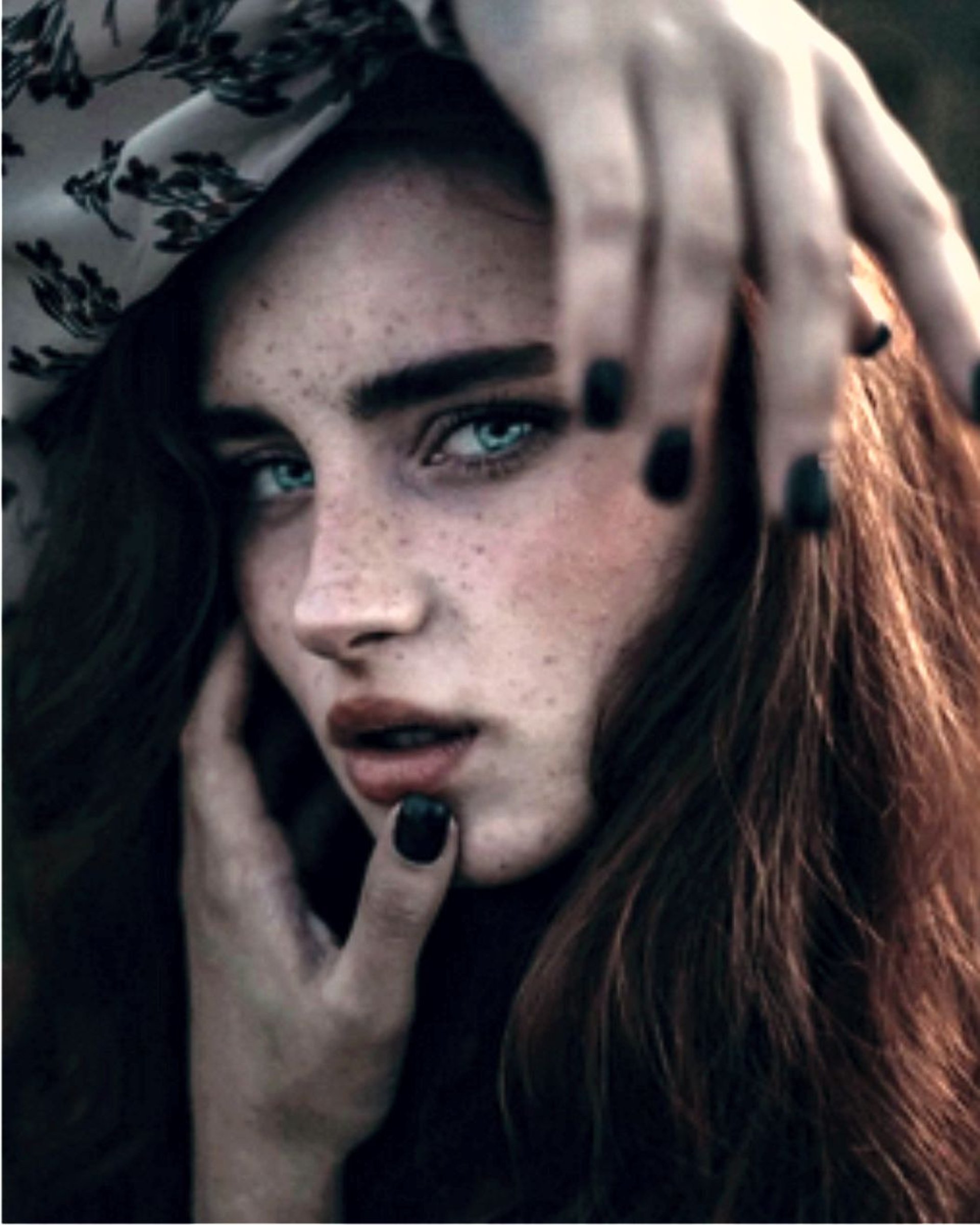 woman with brown hair wearing white and black floral hijab