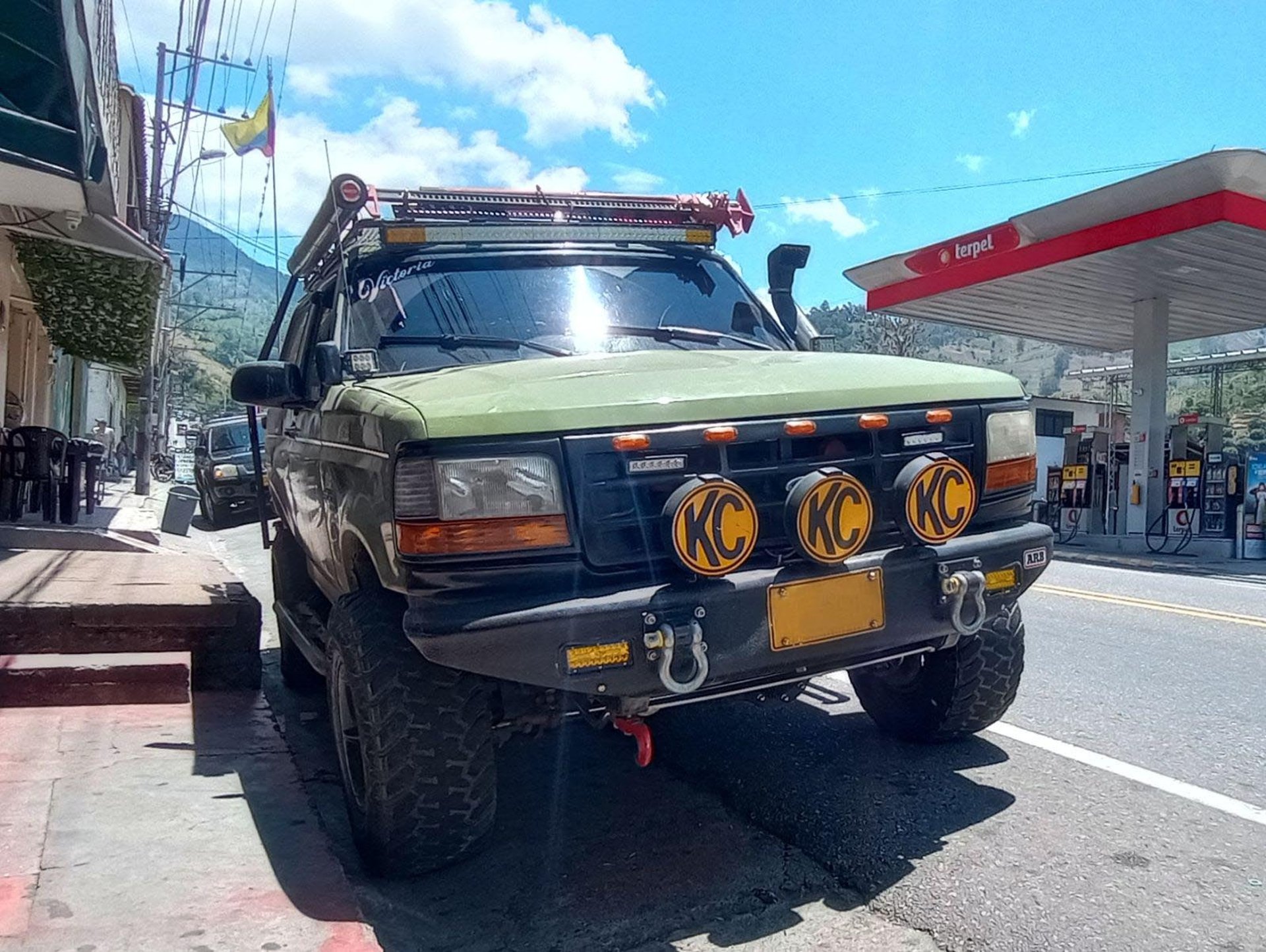 a jeep is parked on the beach at sunset