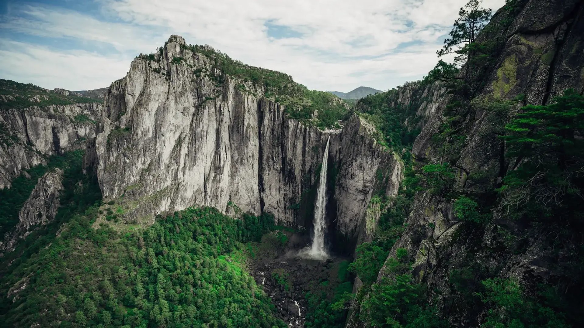 A small building perched on a cliff overlooking a canyon.