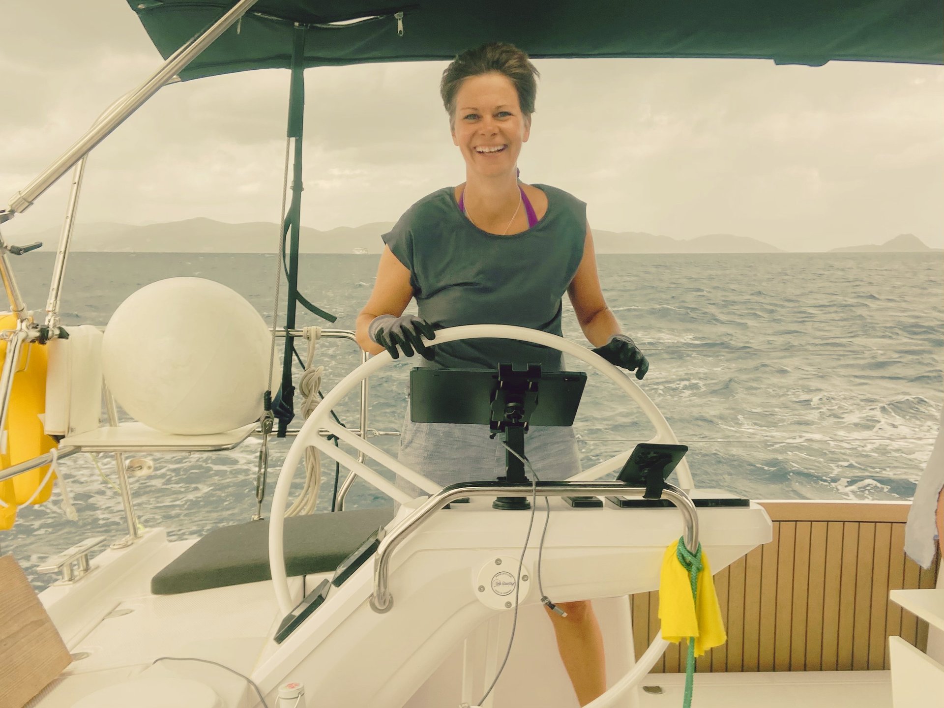 glückliche Stephanie Kabelin am Steuerrad des Segelbootes bei gutem Wellengang und Wind