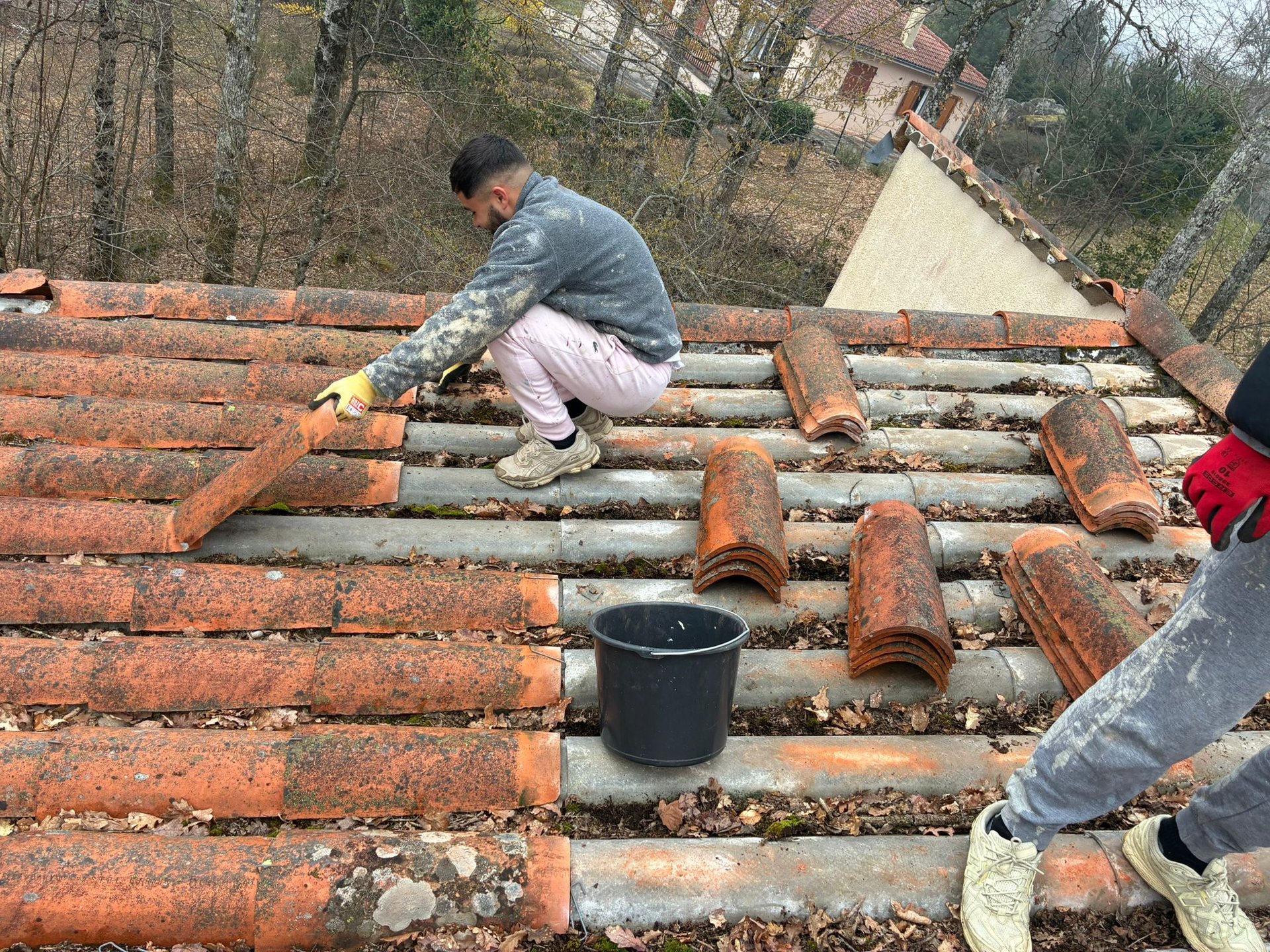 a man in a yellow shirt is working on a roof