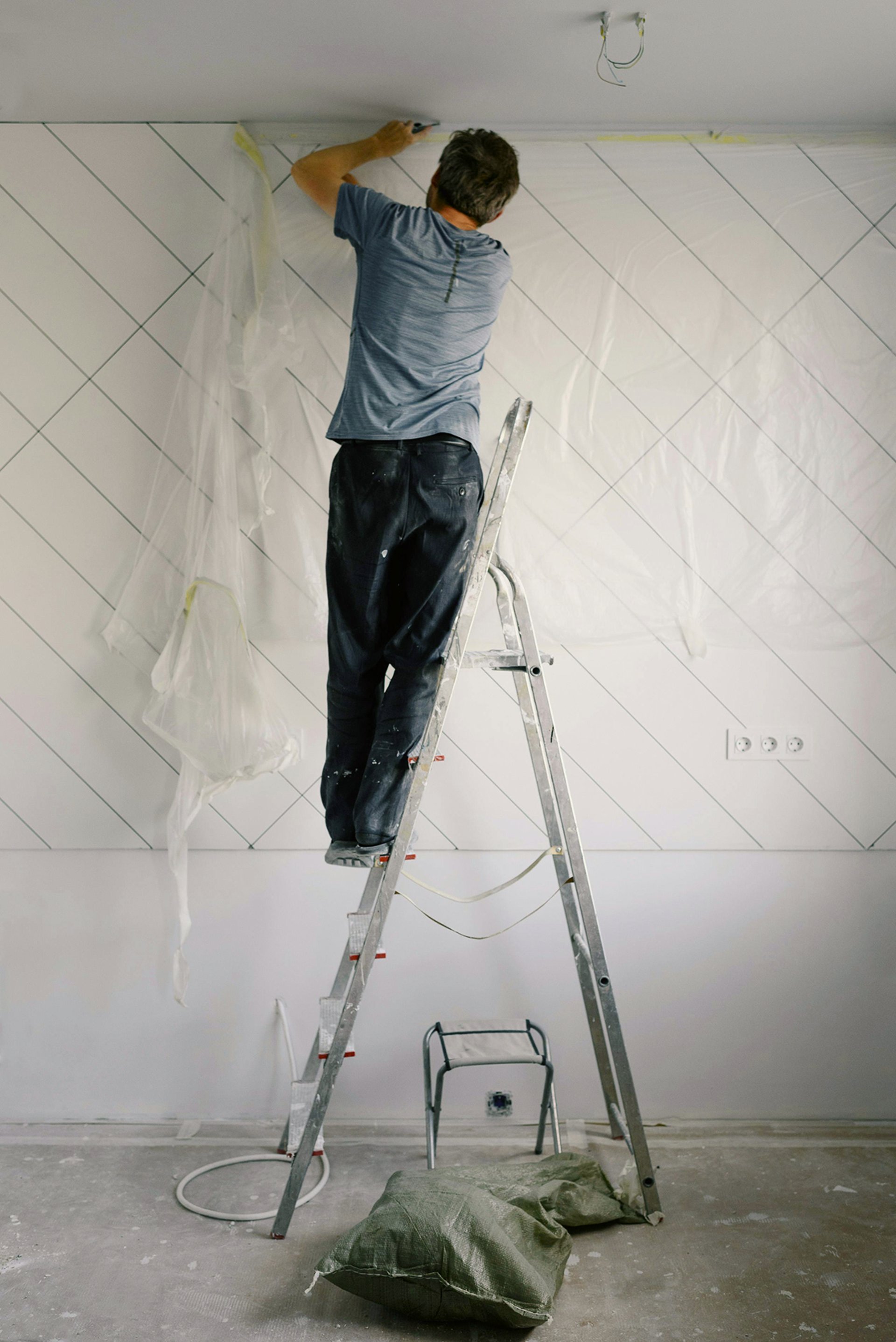 a man with a paint roller painting a wall