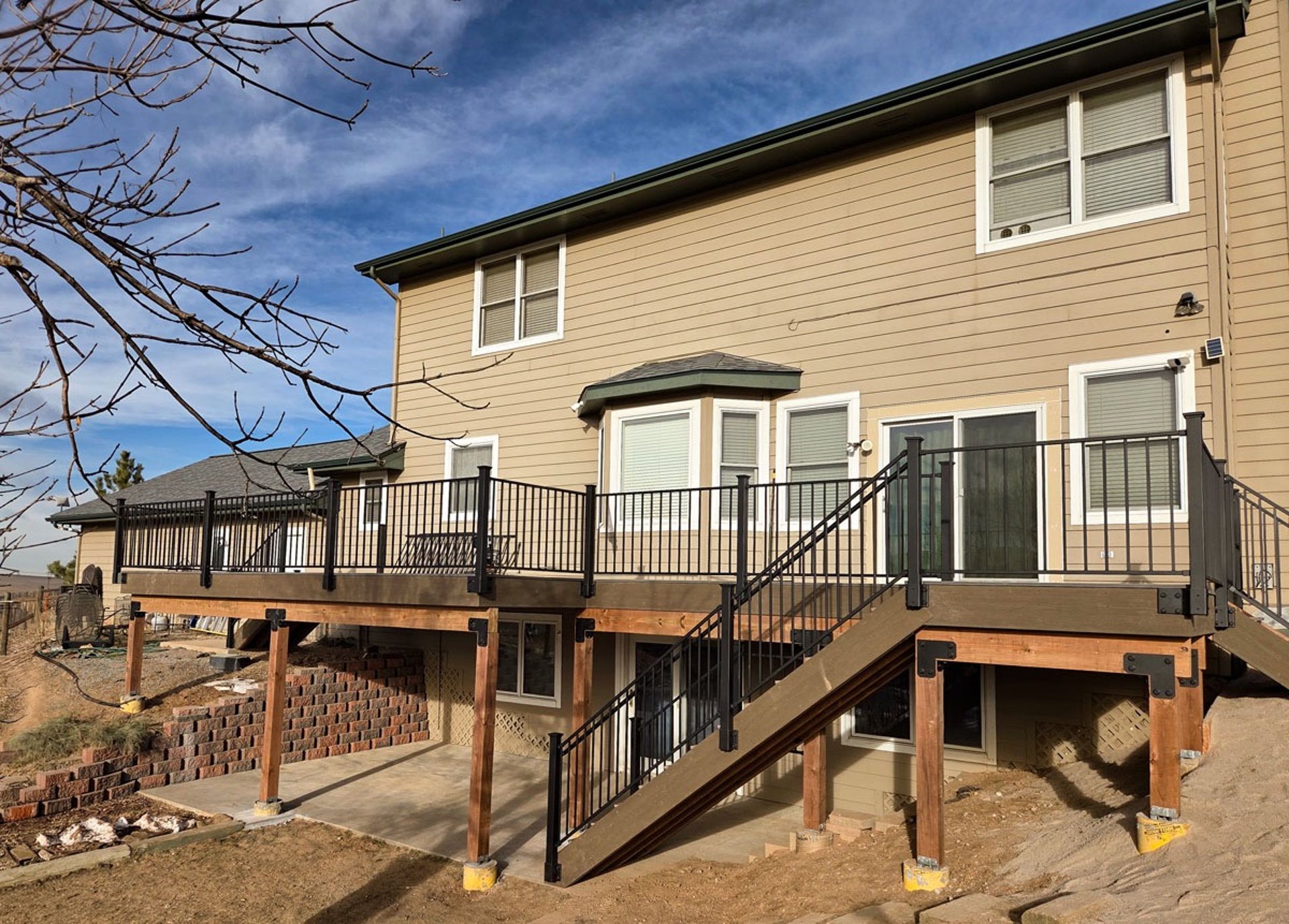 Completed custom deck renovation with composite surface and matching black railing.