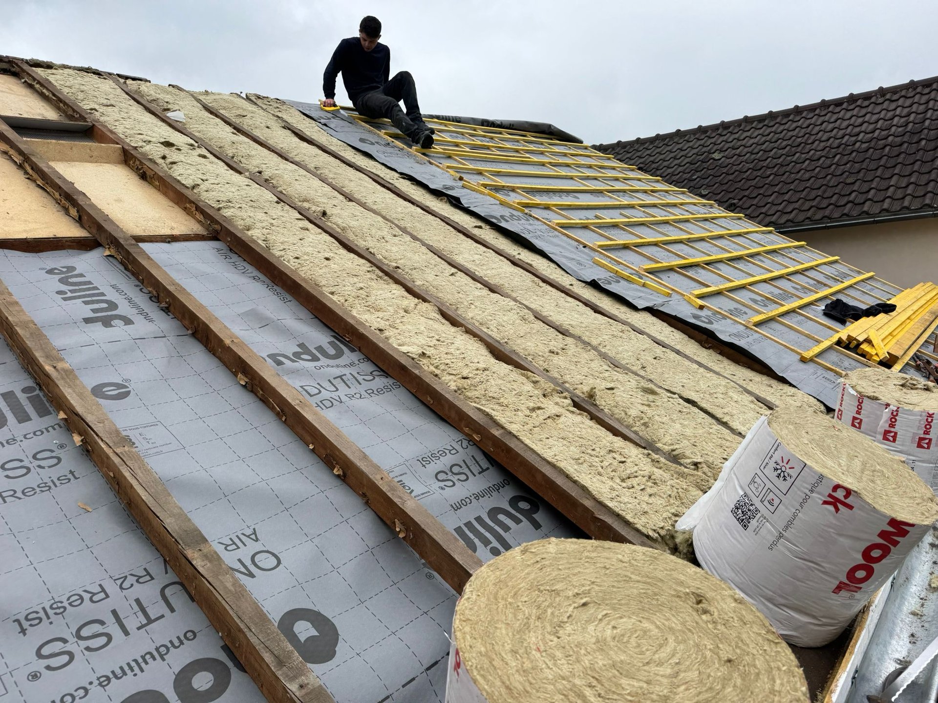 person in blue pants sitting on brown wooden floor