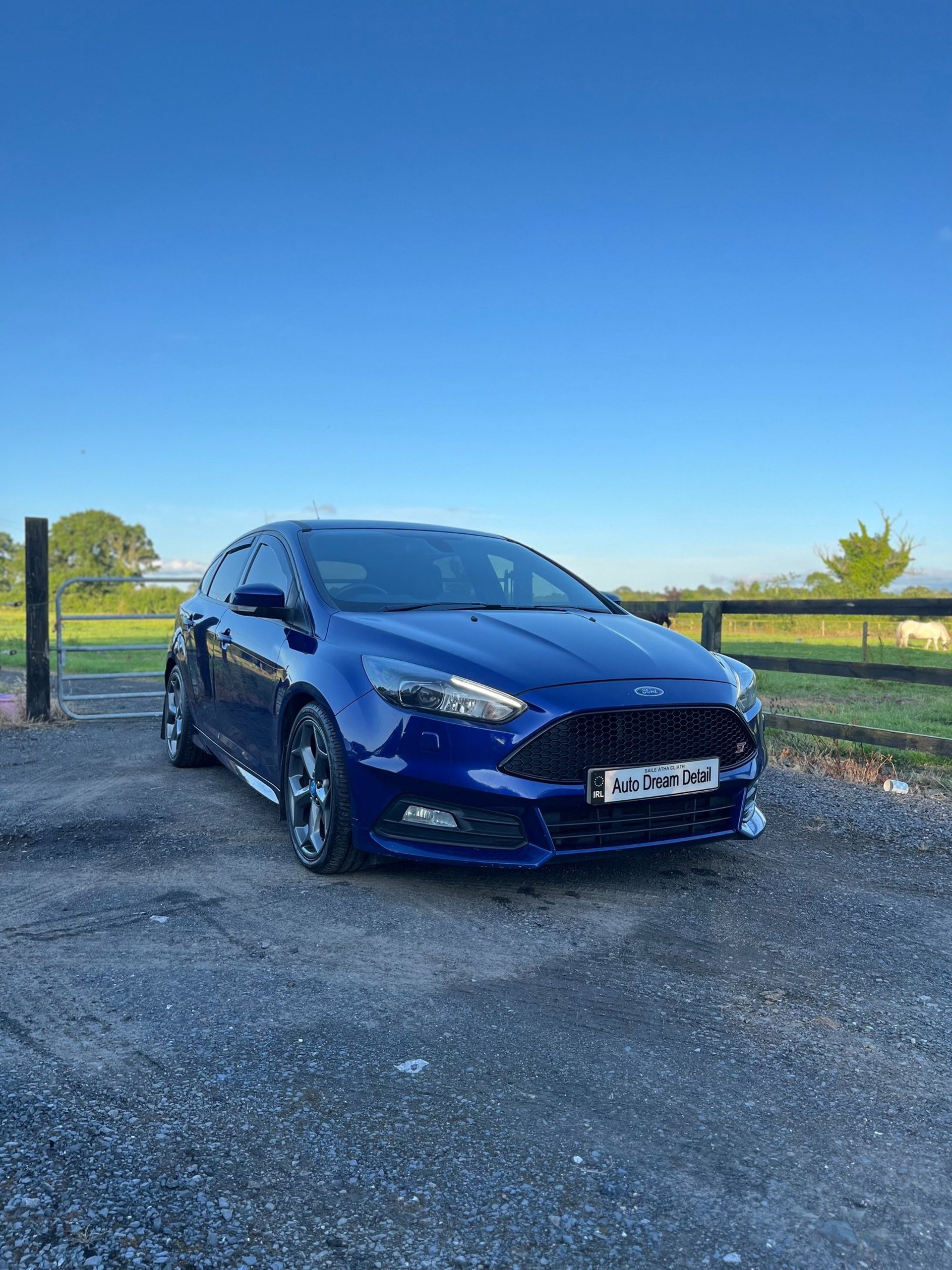 a man sitting in a car with his hand on the steering wheel