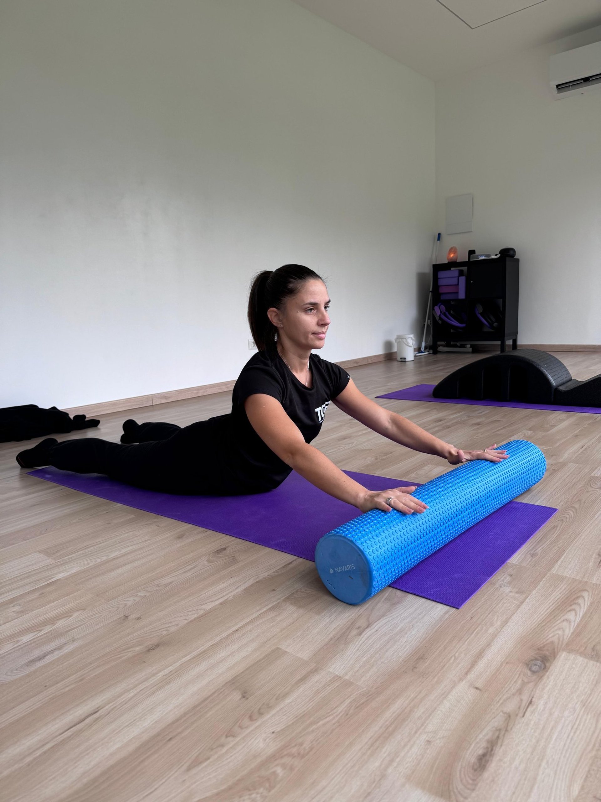 woman in black tank top and black leggings lying on black floor