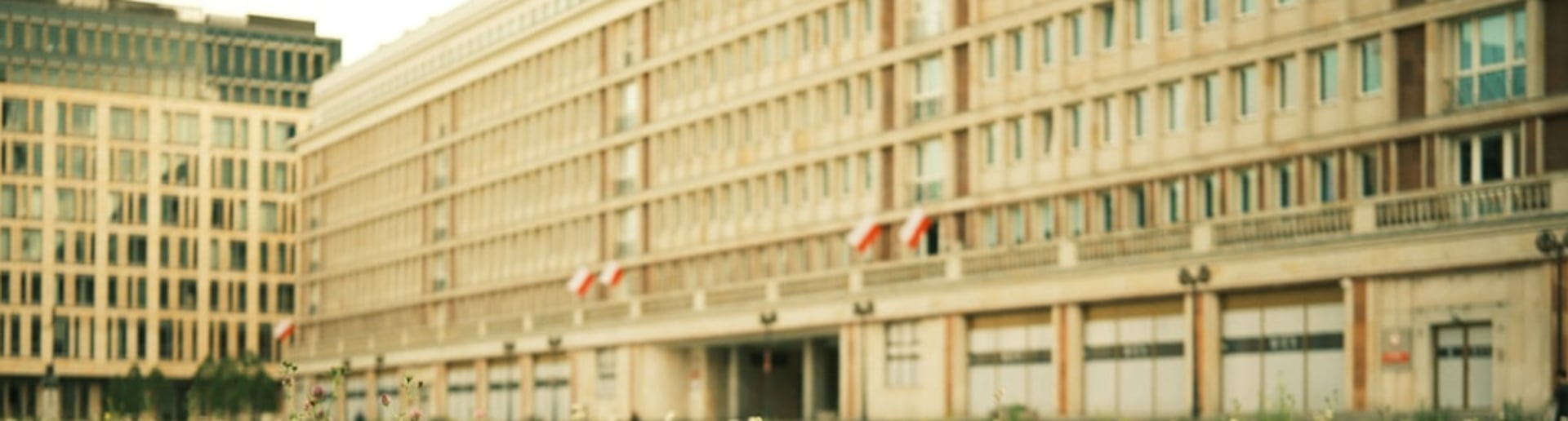 Flowers bloom in front of a building.