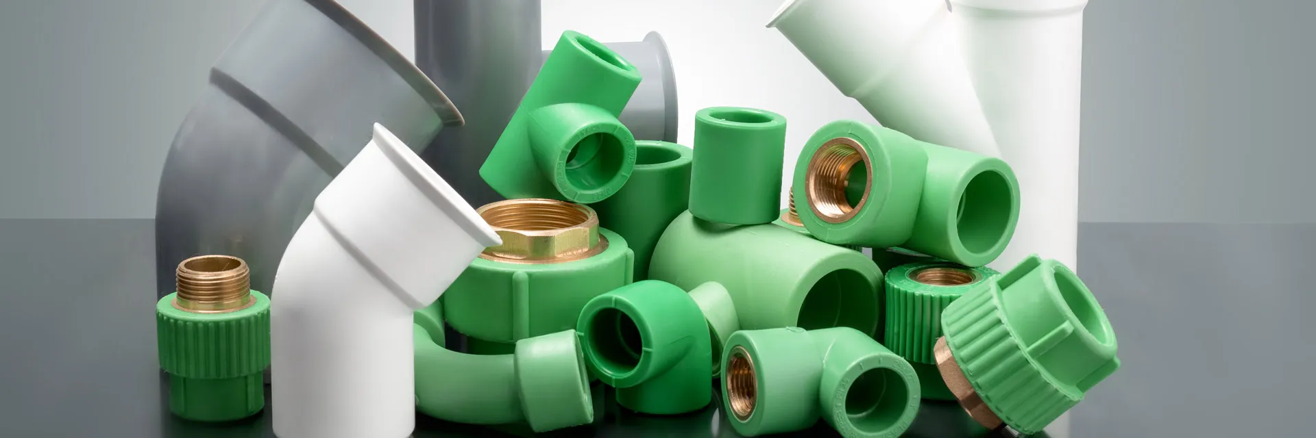 Hand holding a brass fitting on a white tube