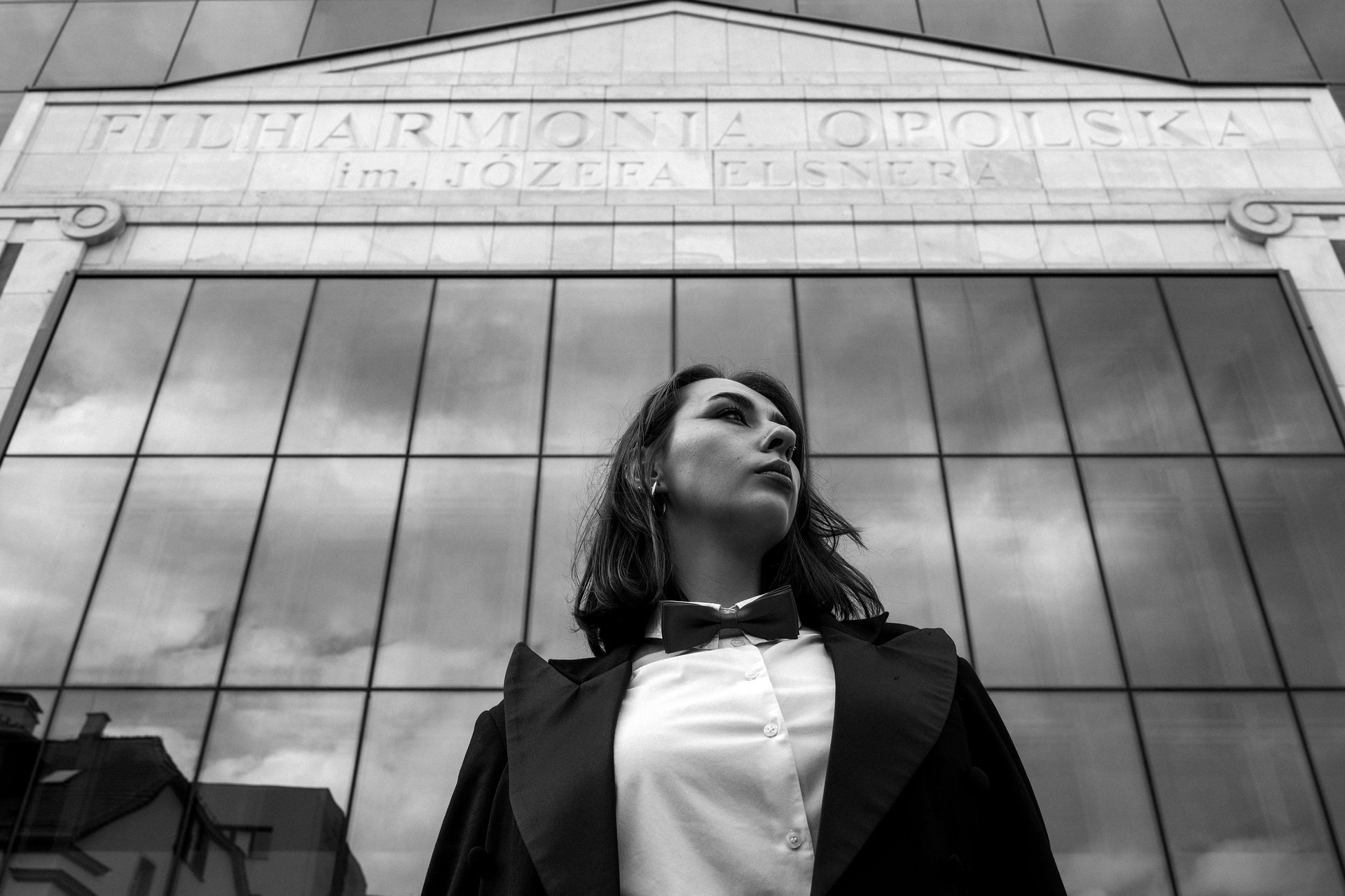 Kobieta na tle Filharmonii Opolskiej w Opolu, portret w czerni i bieli