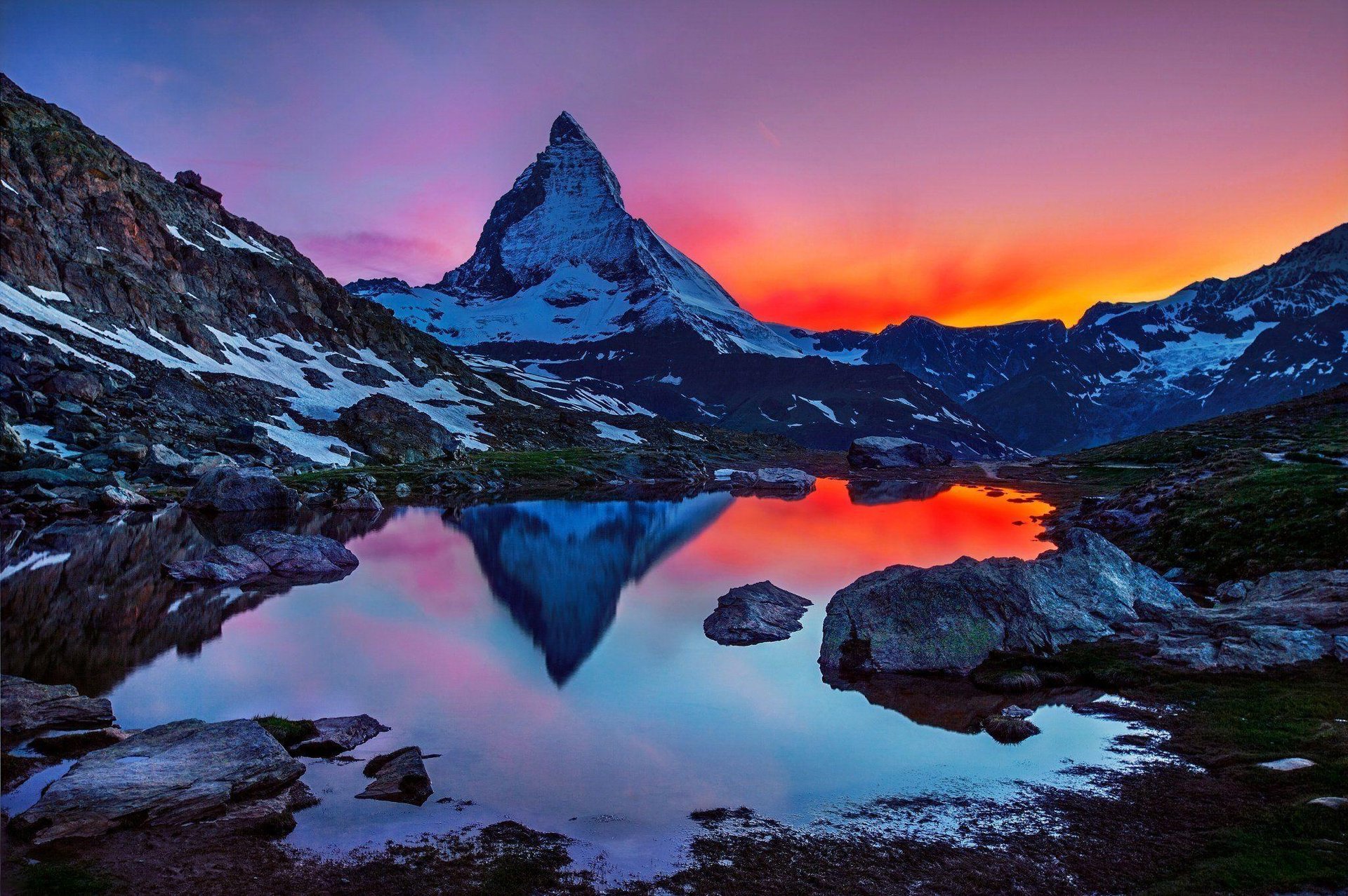 Majestic mountain peak illuminated by golden sunrise reflected sunlight.