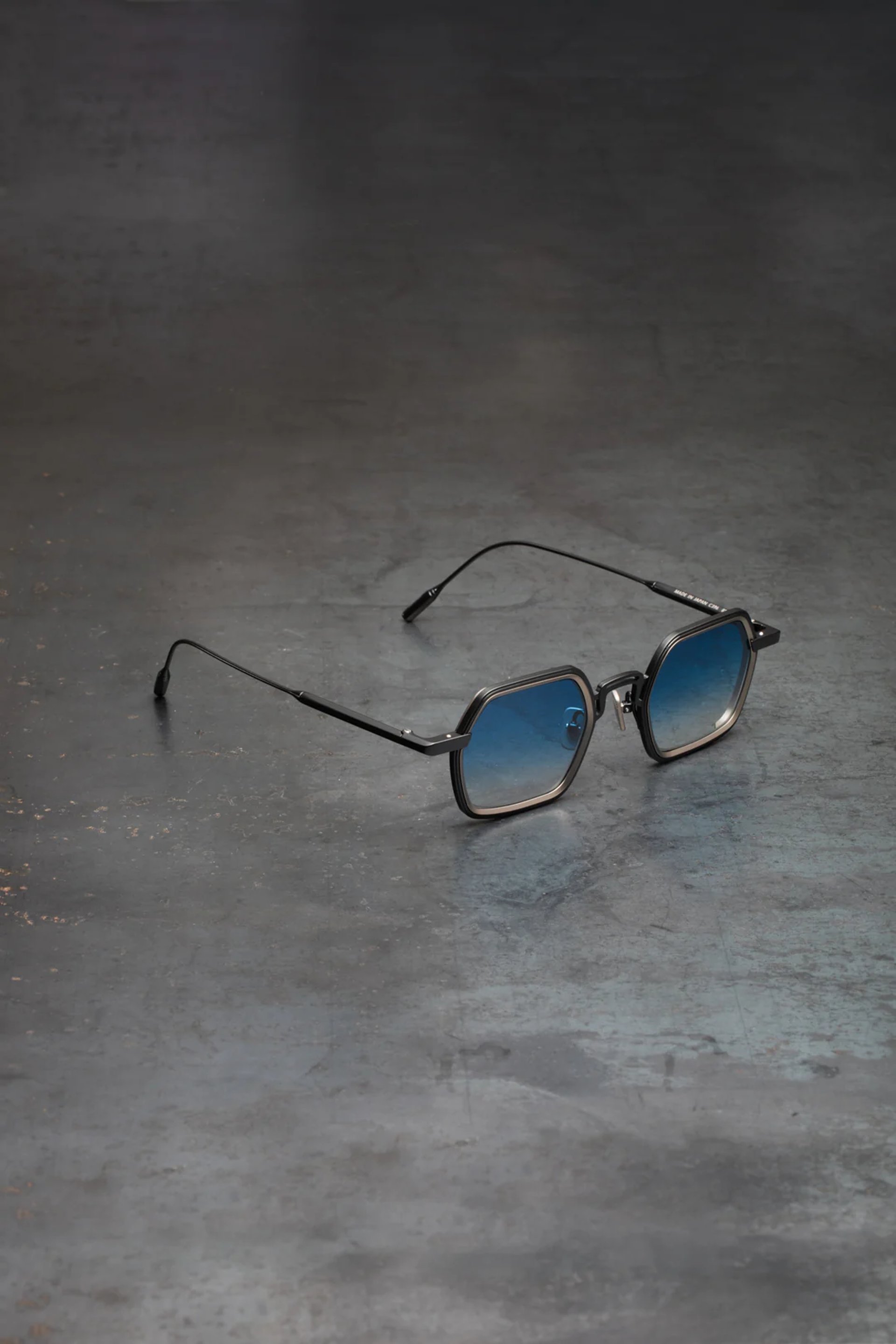 gold framed aviator style sunglasses on brown rock