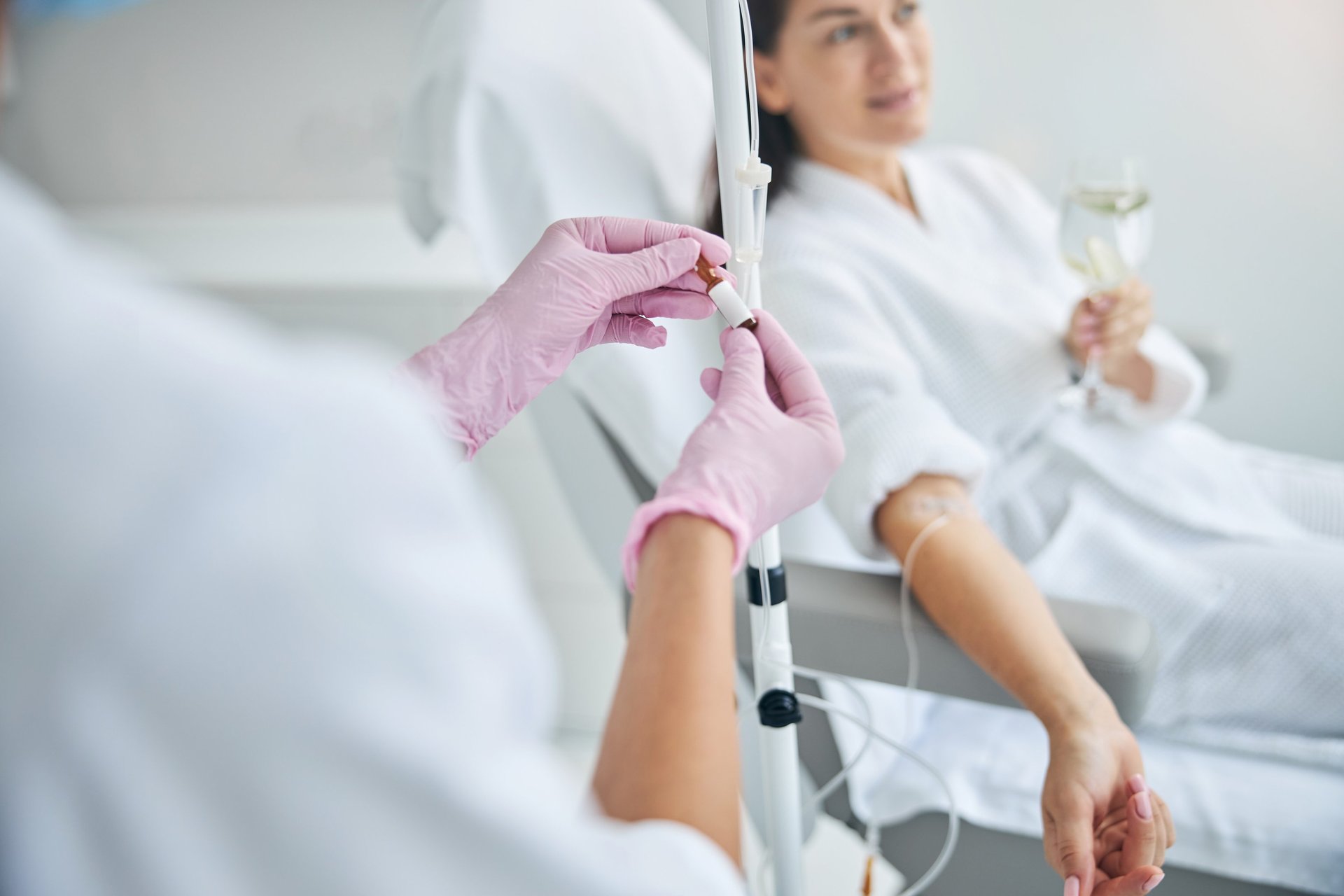 A woman in a hospital gown is getting an injection
