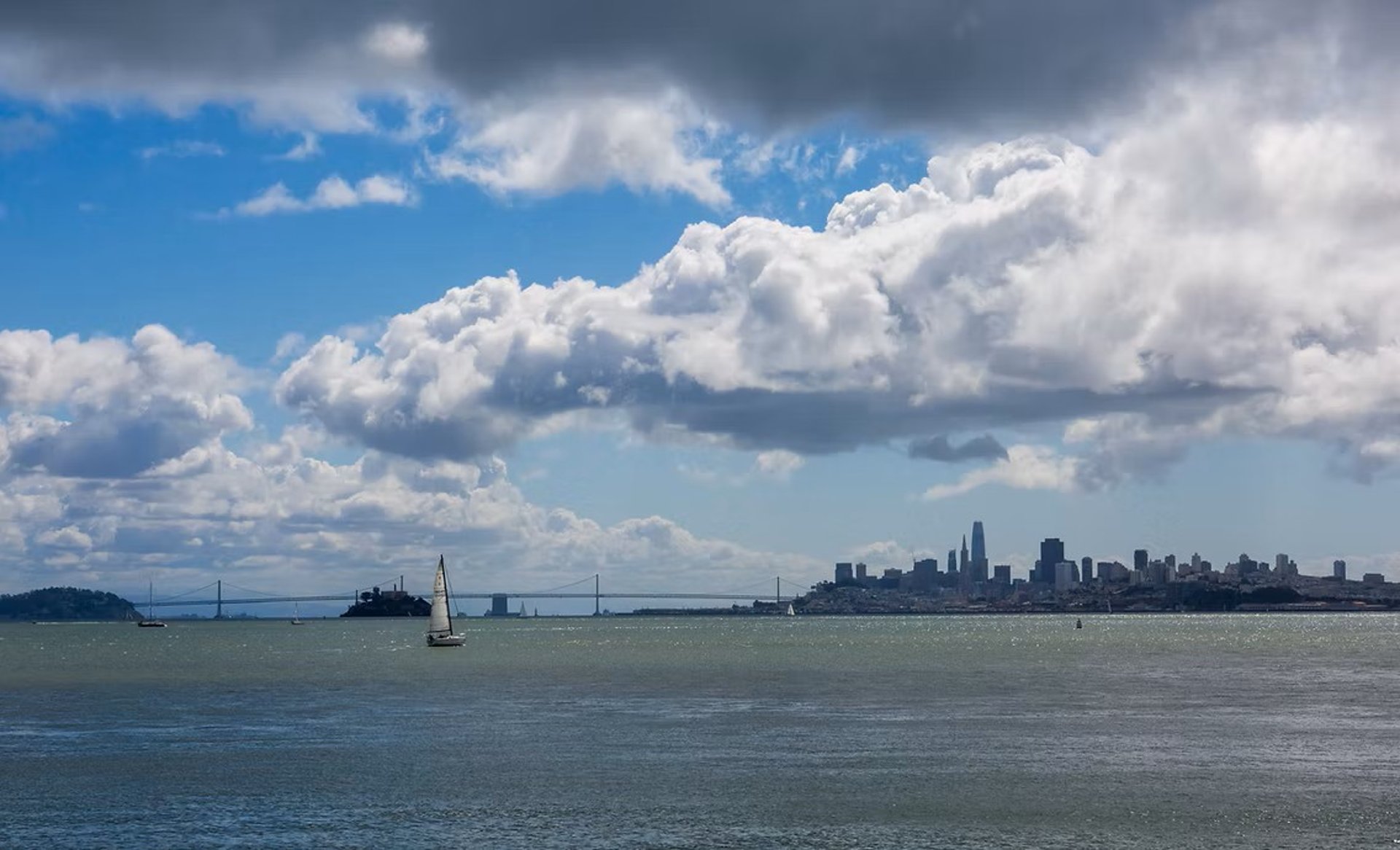 woman wearing yellow long-sleeved dress under white clouds and blue sky during daytime