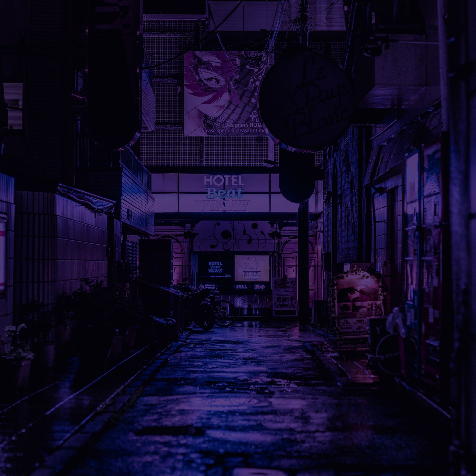 A dark alley way with neon signs on it