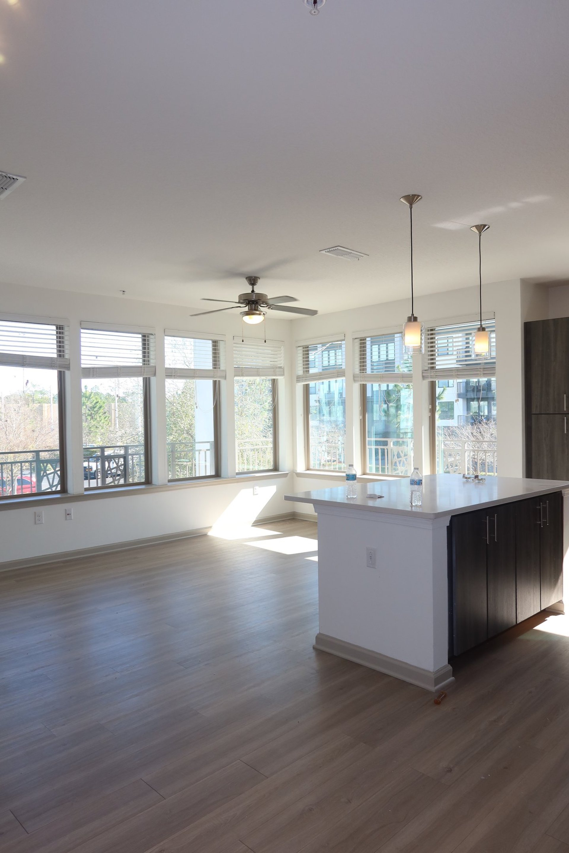 a woman in a green shirt and black gloves vacuuming a gray ottoman