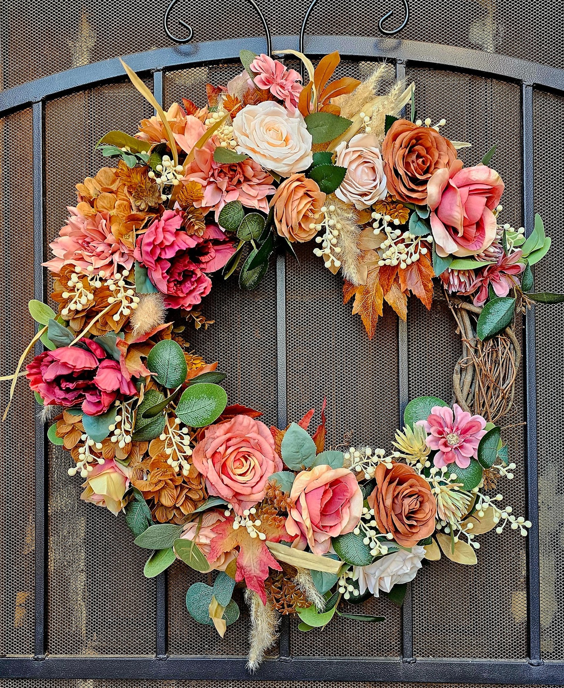 Luxury permanent botanical autumn wreath with terracotta roses, peonies, and fall foliage on a grapevine frame