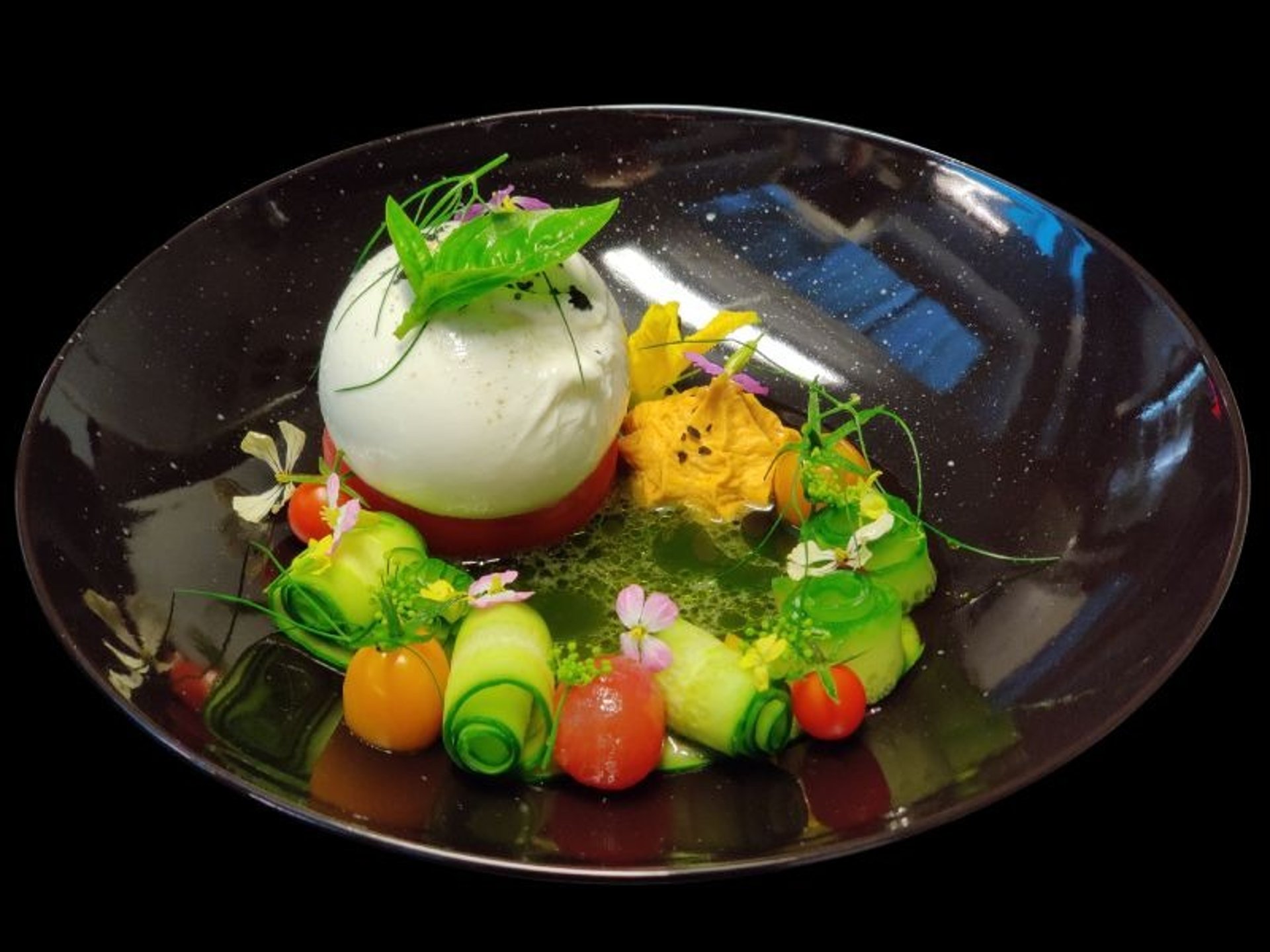 Summer burrata salad with fresh garden herbs and edible flowers