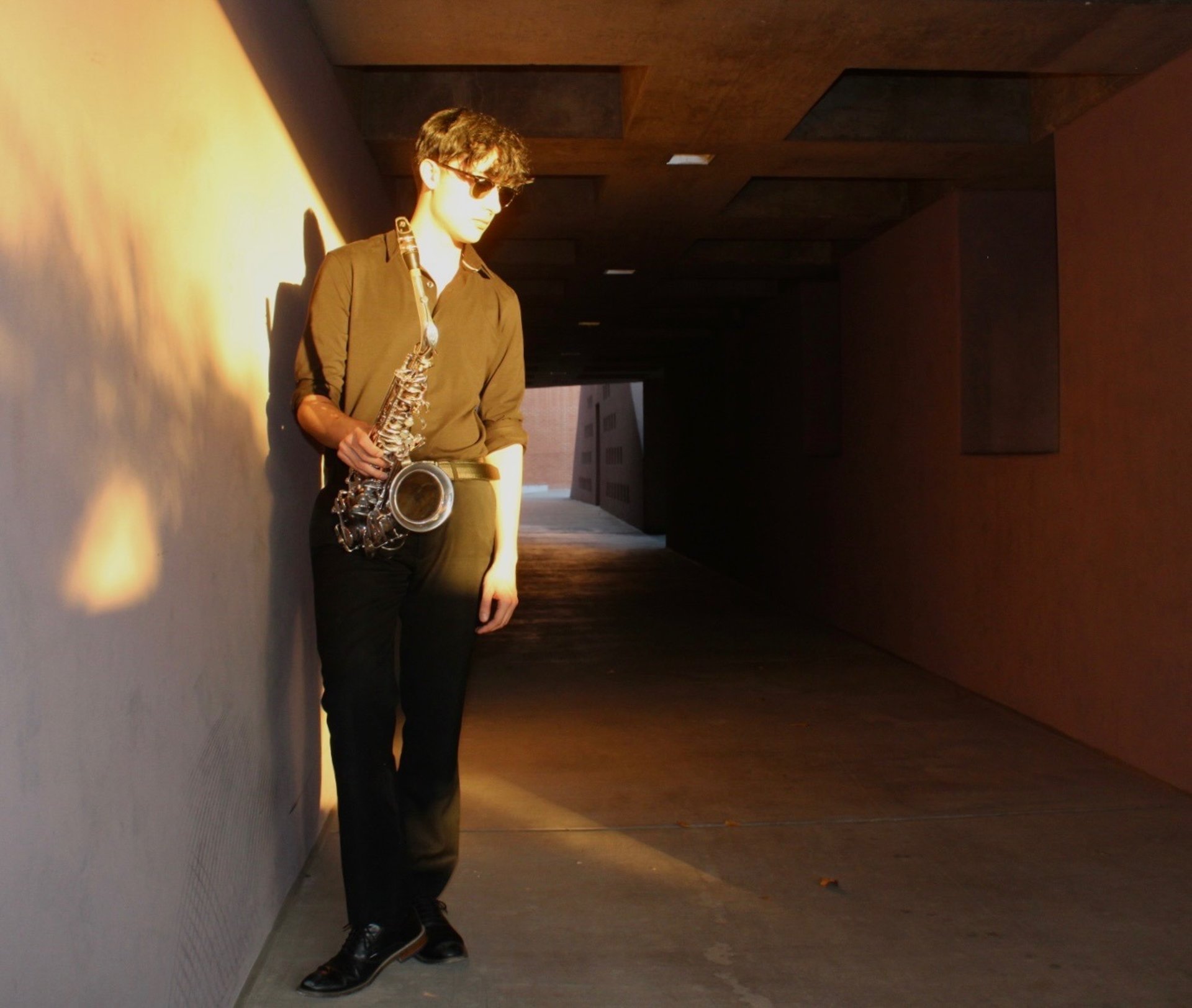 A man playing a saxophone in a dark room