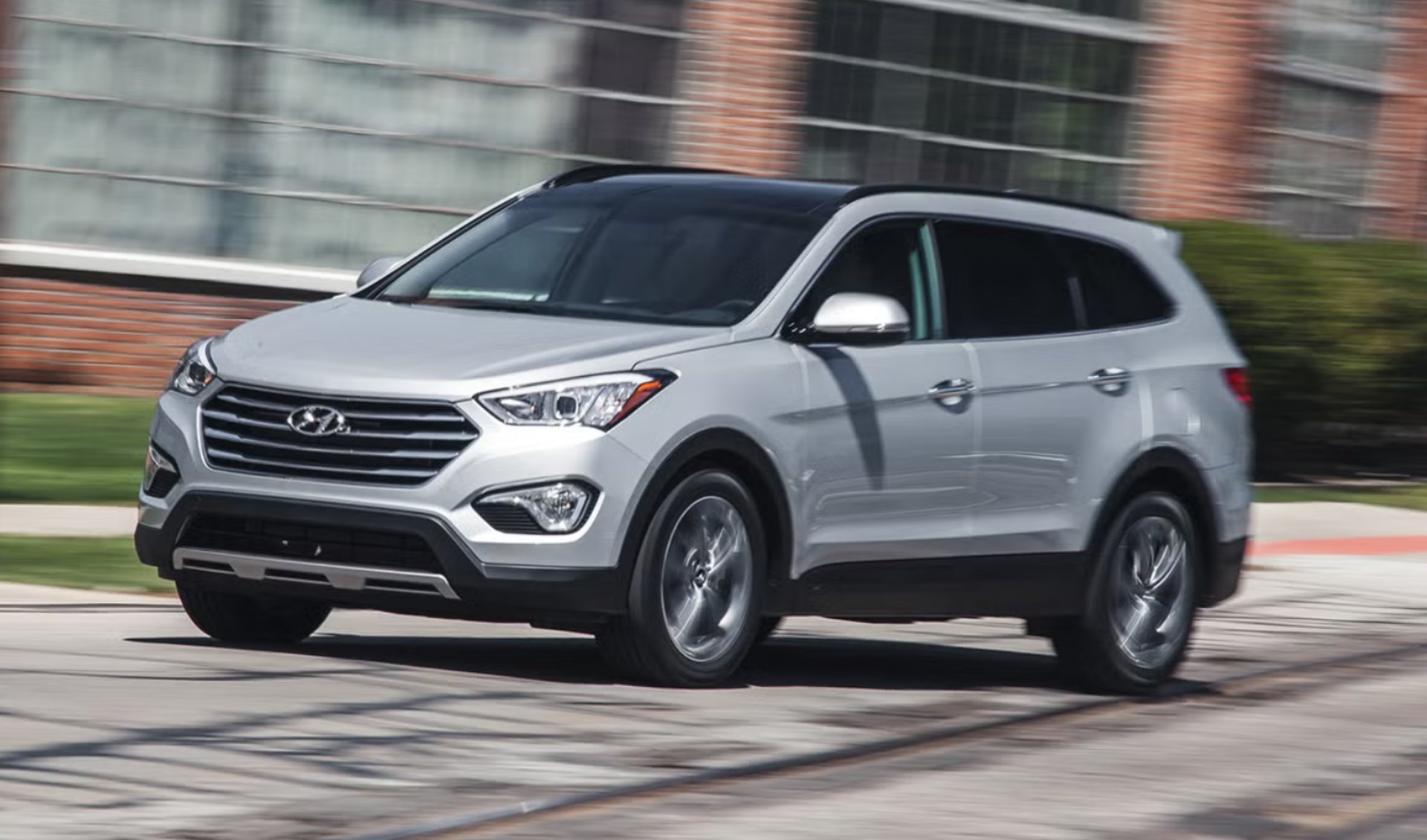 An old red car parked in front of a gas station