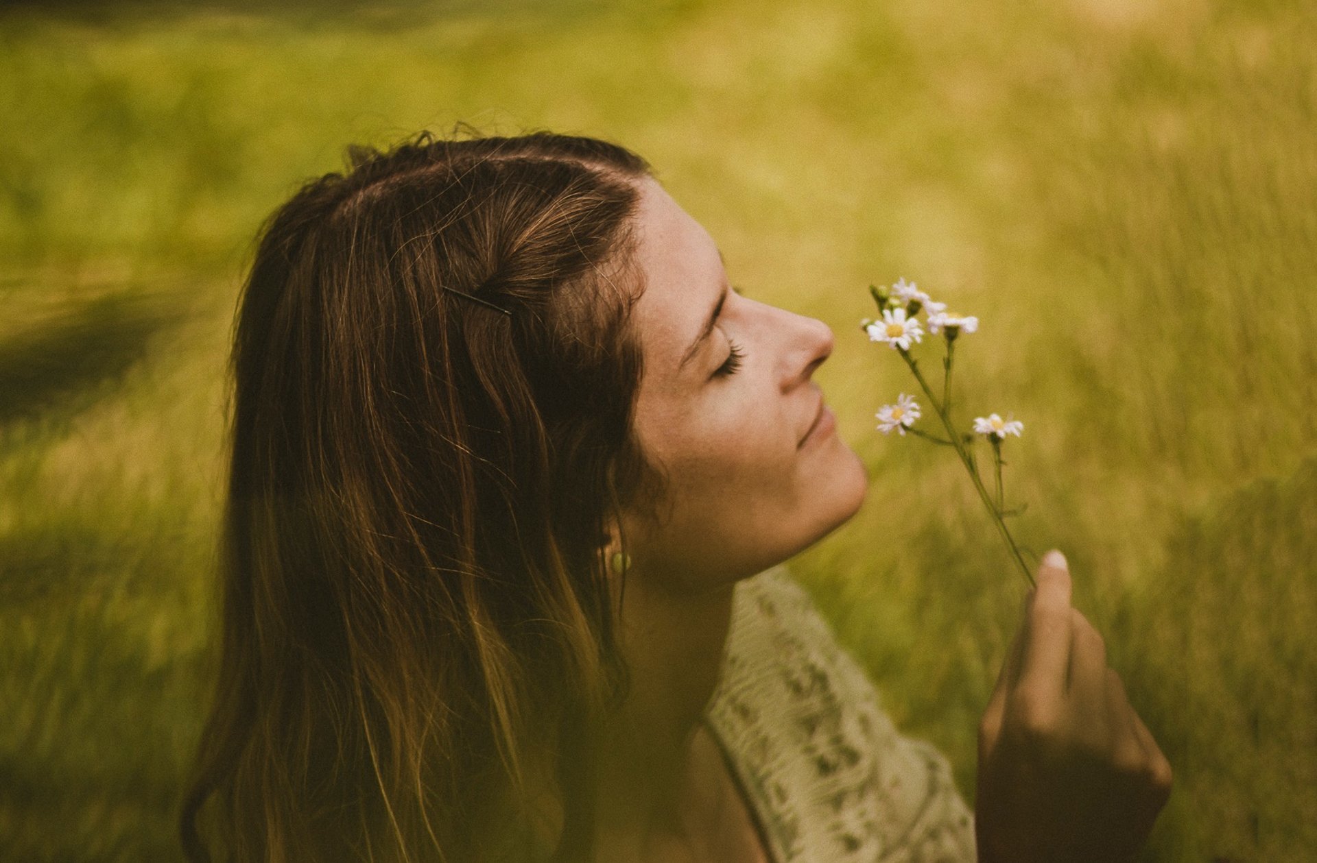 woman sitting in bathtub with white and yellow daisy flowers