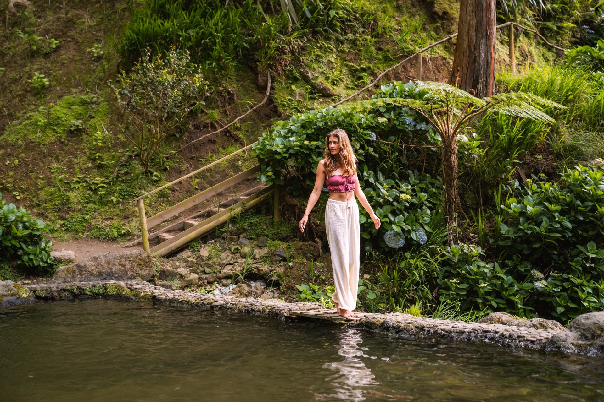 woman in brown and white floral dress standing on green grass field during daytime