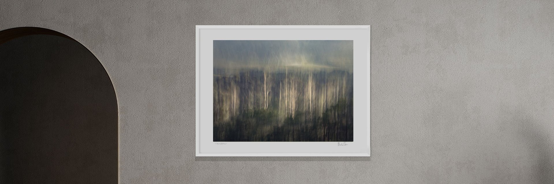 Ethereal landscape photography print of abstract forest by Martin Osner in a white frame on a grey wall..