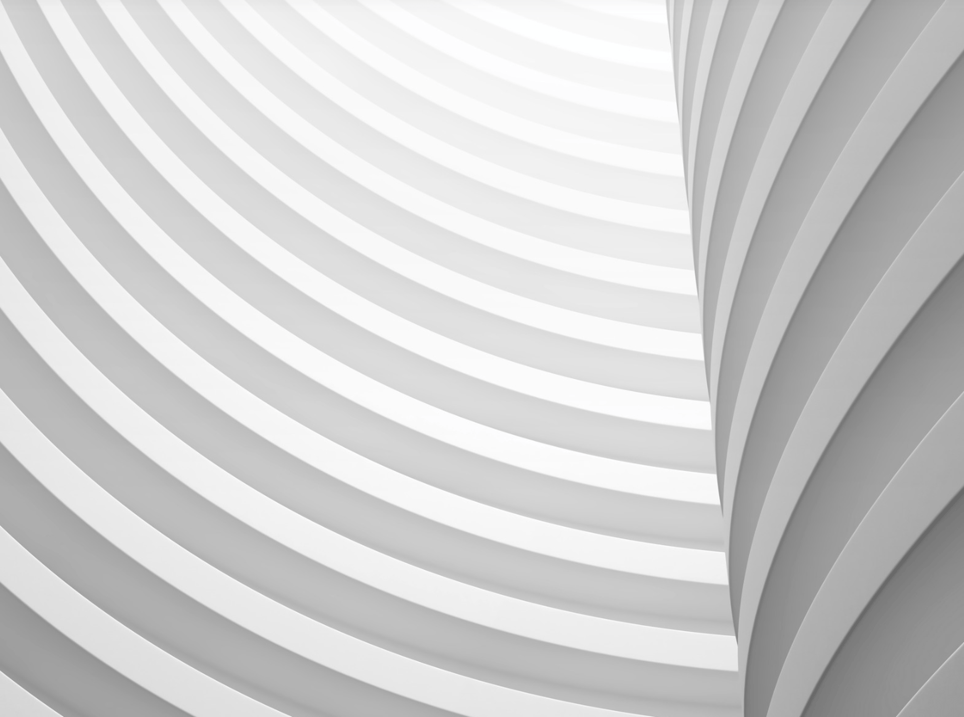 an abstract photo of a curved building with a blue sky in the background