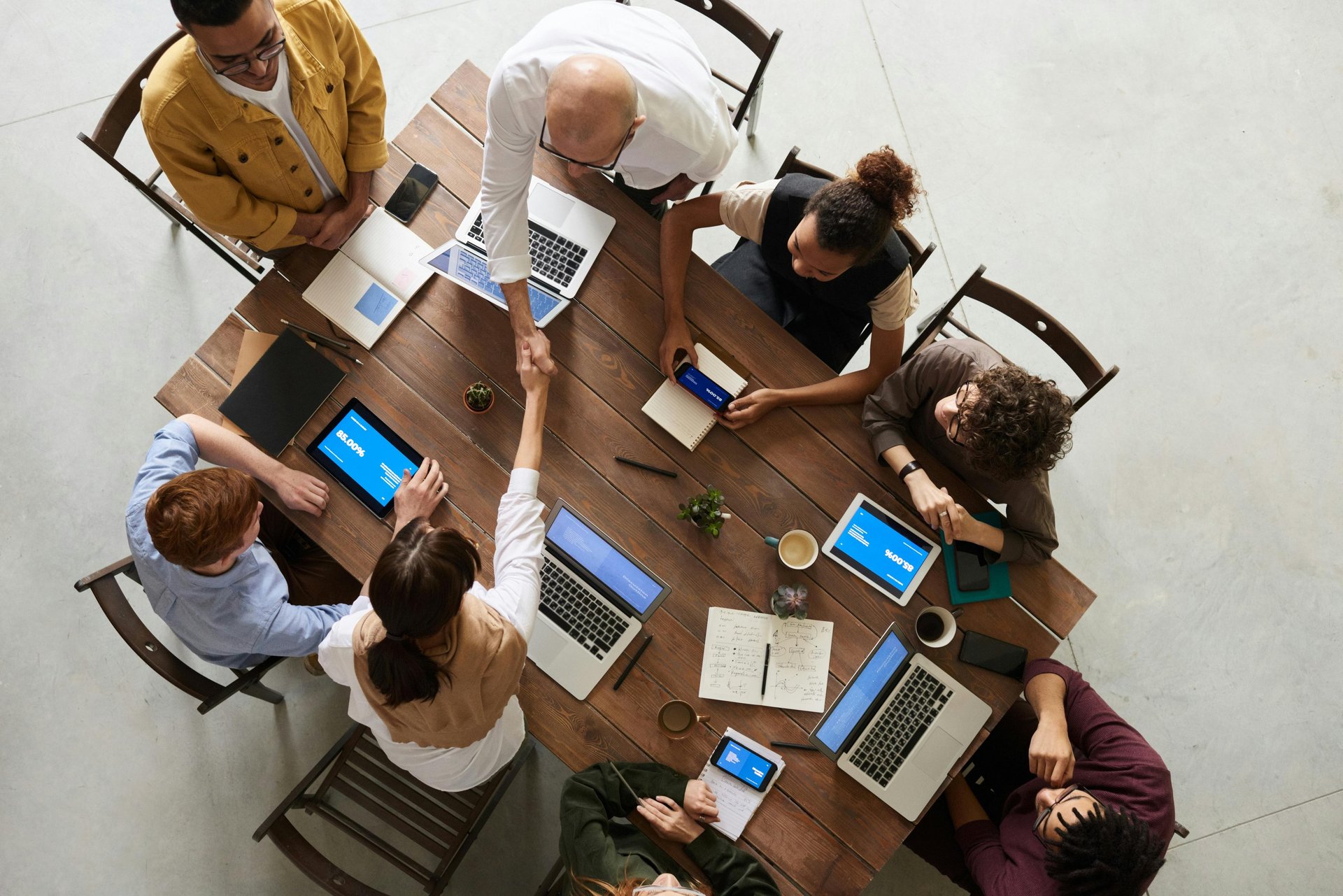 man standing in front of people sitting beside table with laptop computers