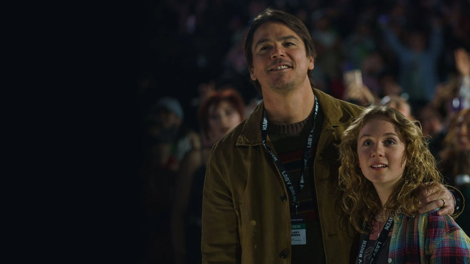 A man holds his daughter at a concert