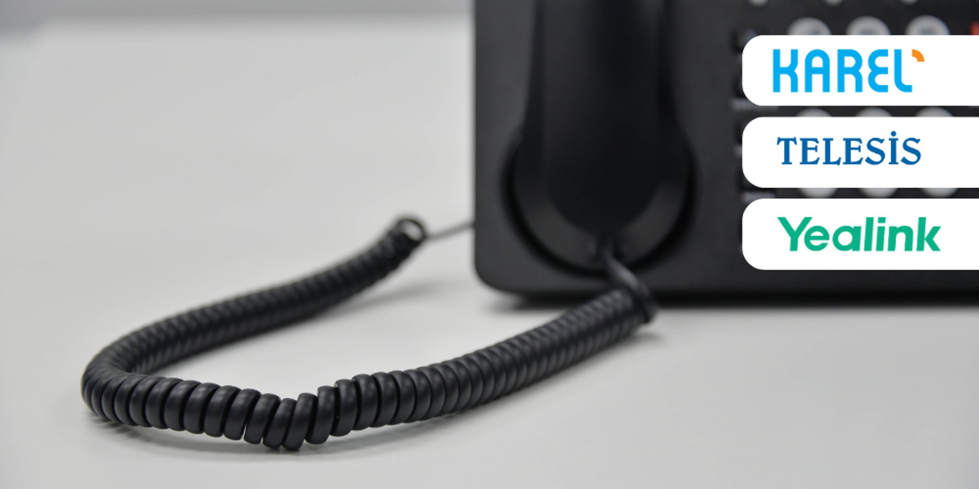 black ip desk phone on black wooden table