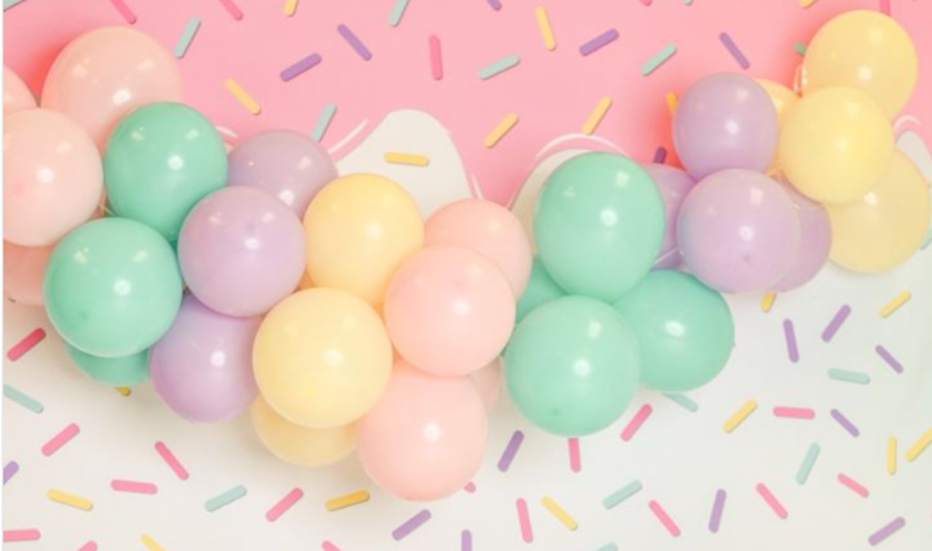 person holding pink and white balloon