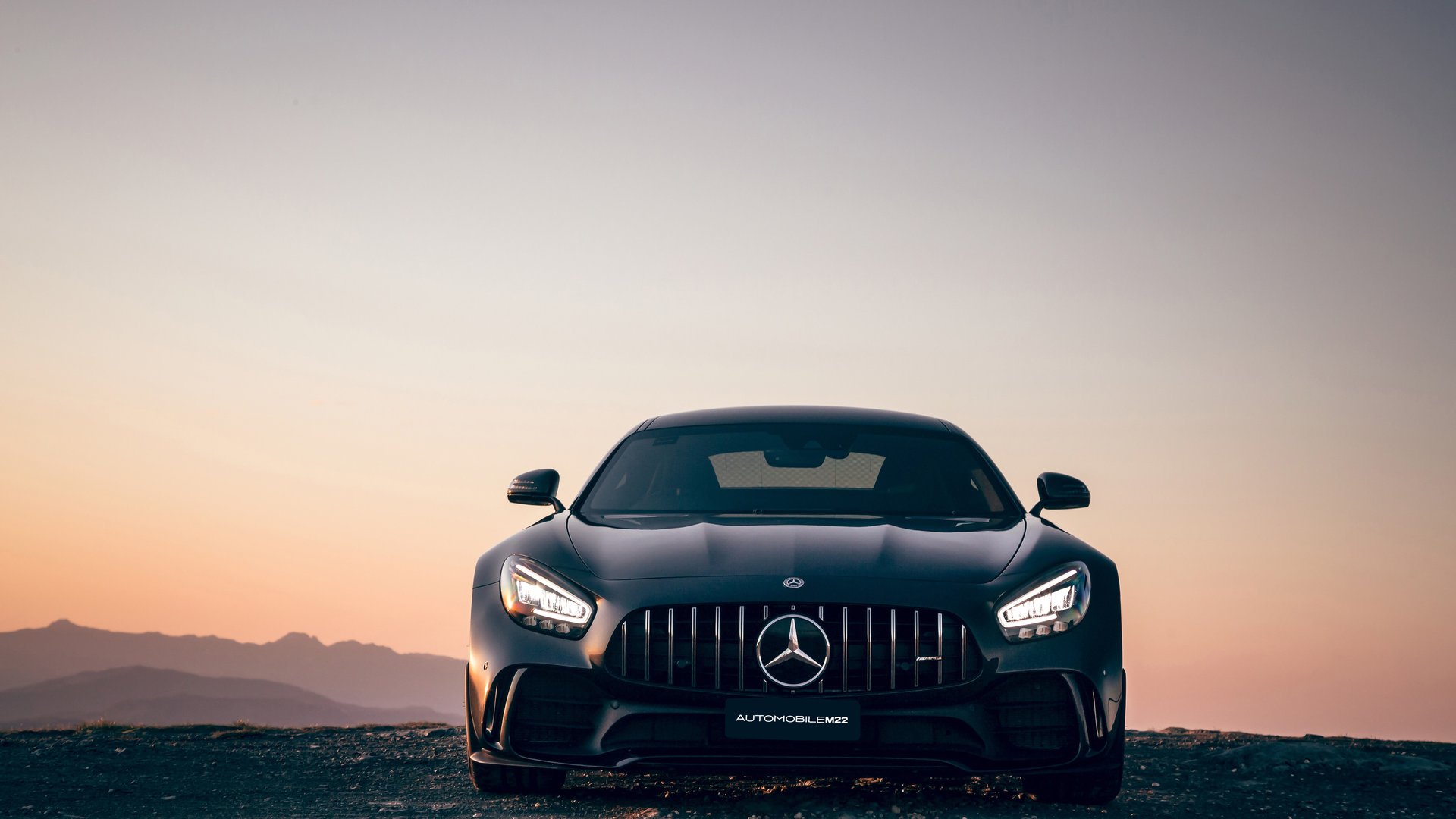 Vue de fond mettant en scène une voiture Mercedes de luxe sur une route panoramique