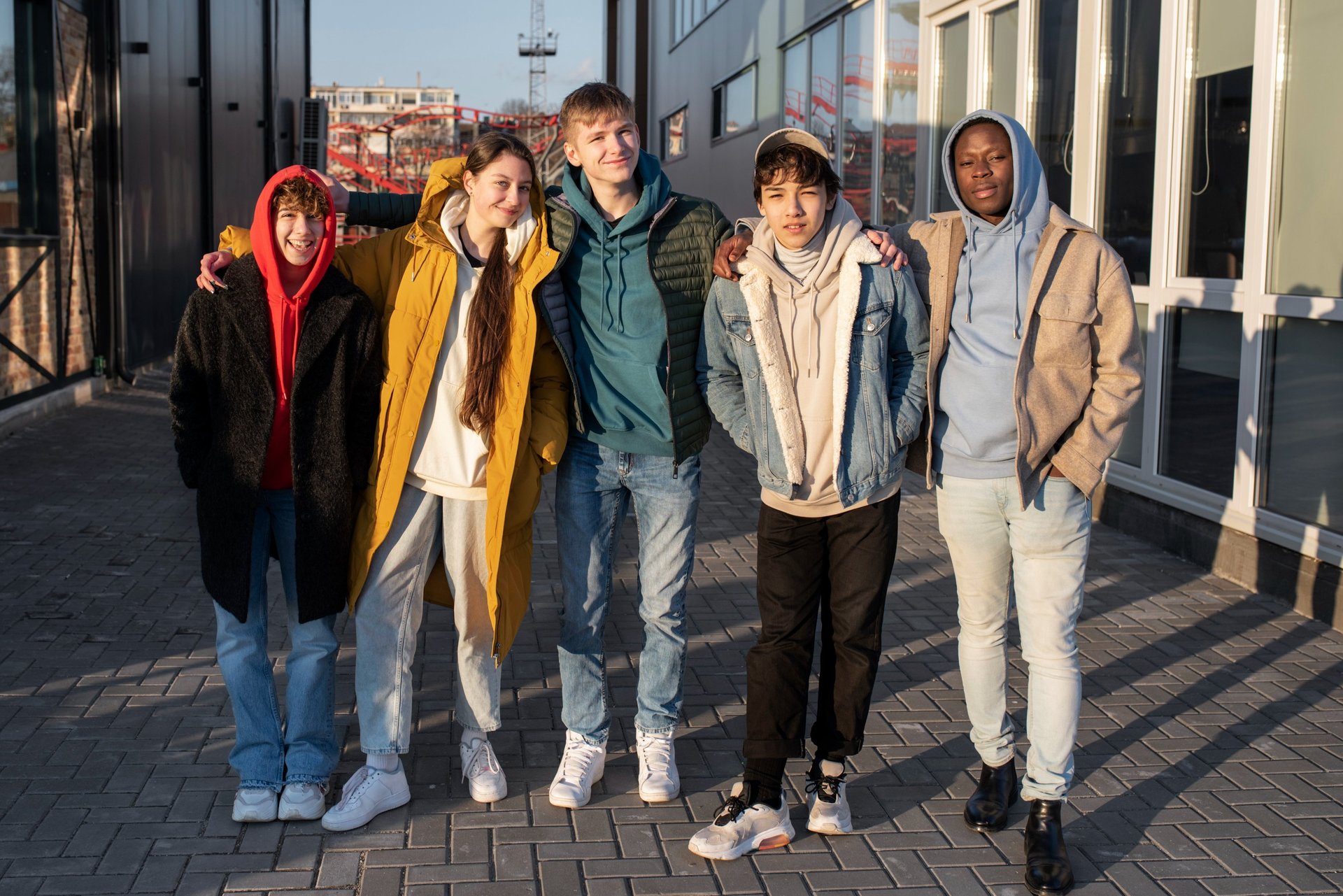 a group of people standing around a man sitting on a bench