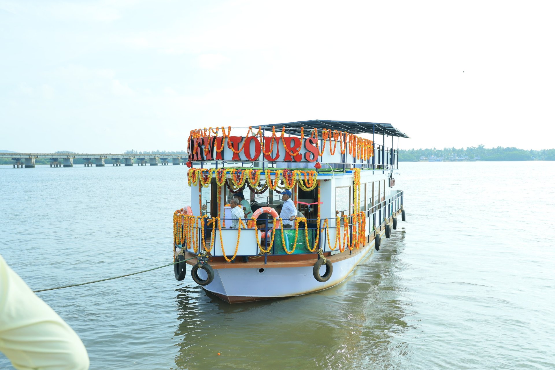 man in gray jacket and black backpack standing on green grass field near mountain during daytime