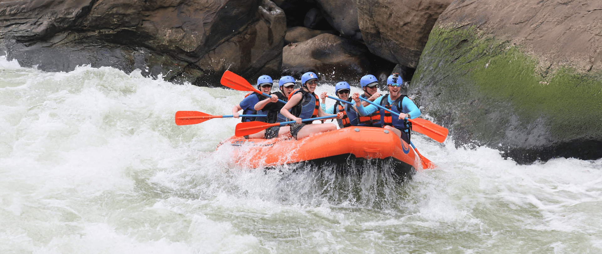 people riding orange kayak on river during daytime