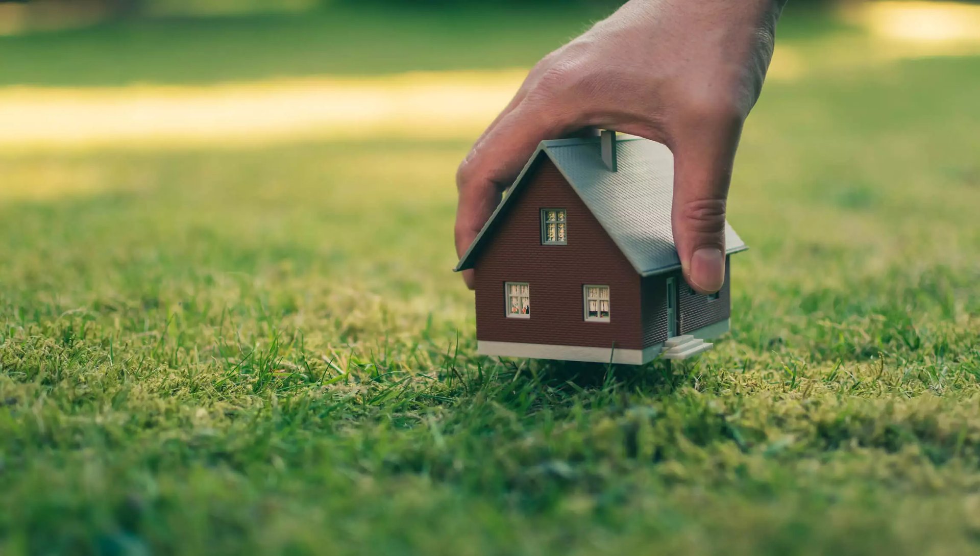 brown wooden house with green grass field